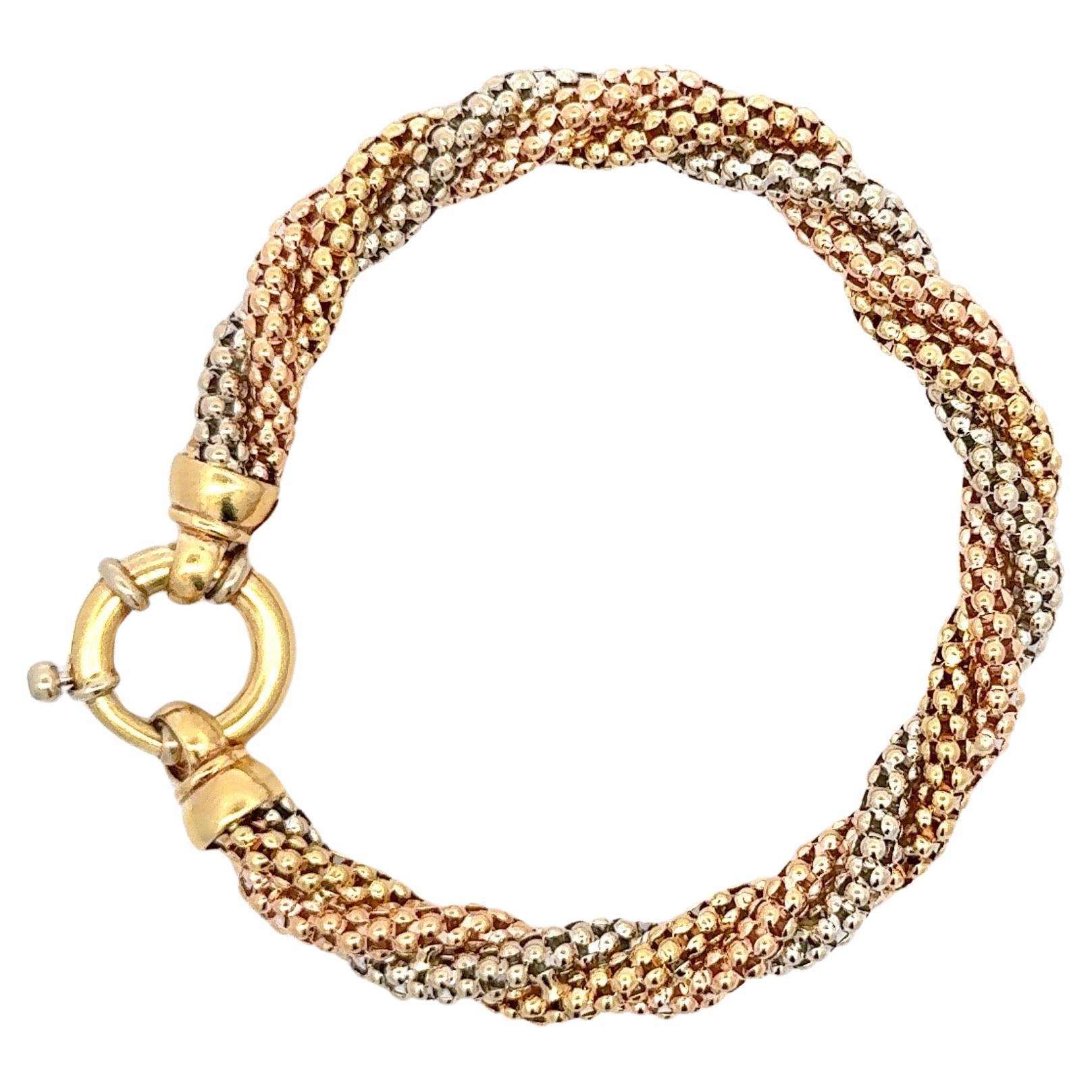 18 Karat gold bracelet featuring rose, white & yellow gold in a twist beaded motif weighing 23 grams.

