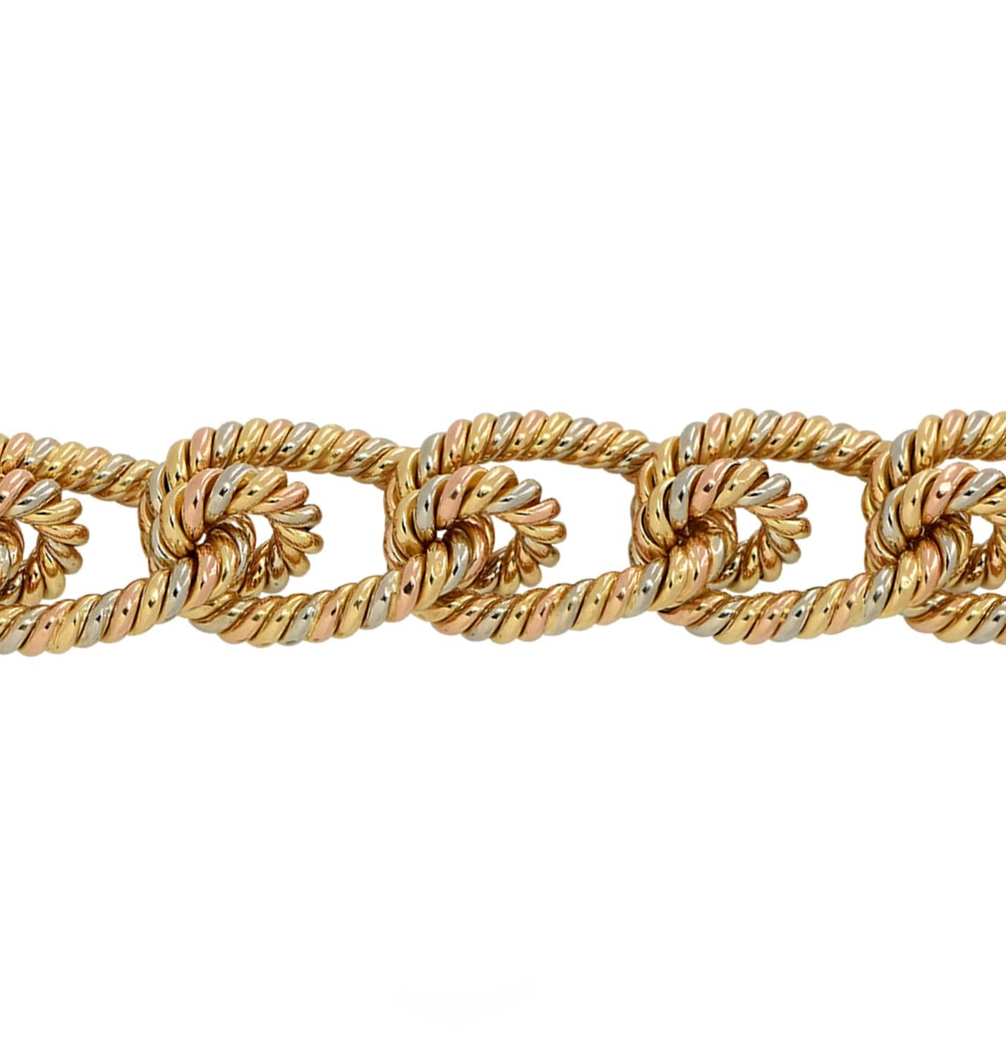 Striking bracelet crafted in 18 karat yellow, white and rose gold twisted to create a rope effect. Tri-color gold rope hoops link together to create this spectacular look. This bracelet measures 8 inches in width and .9 inches in length, and weighs
