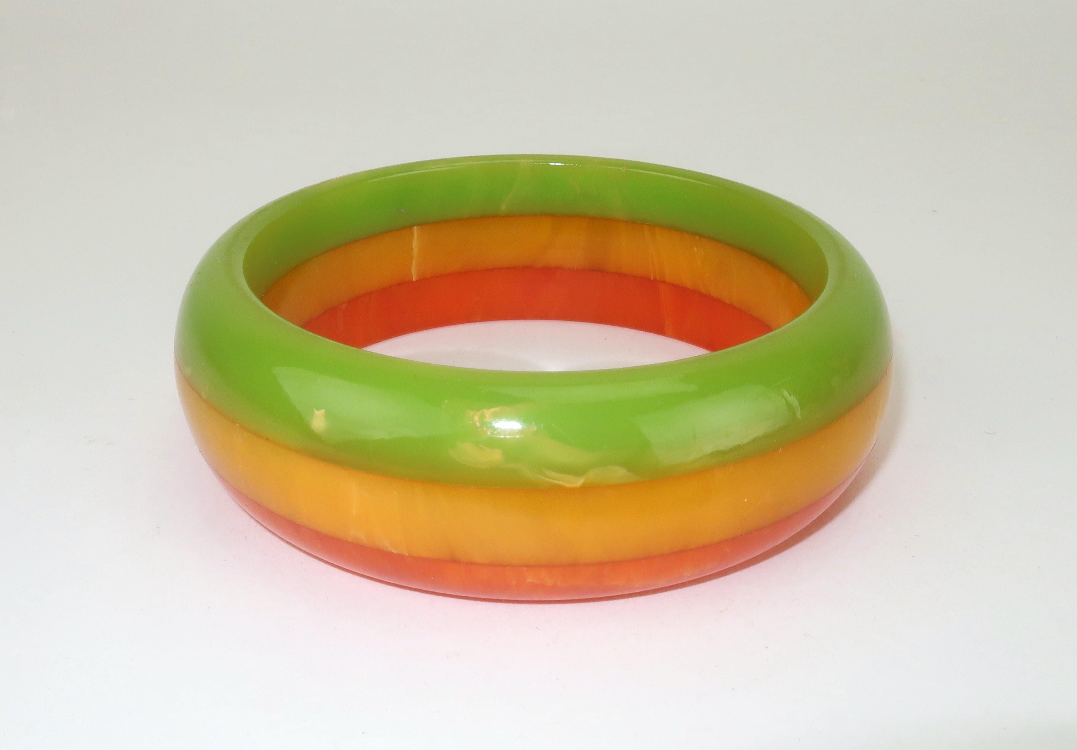 C.1950 tri-color marbleized Bakelite bangle bracelet in shades of amber orange, butterscotch and light olive green.  The three shades fused together make a great combination reminiscent of old school life savers candy.  The bangle shape is fun to