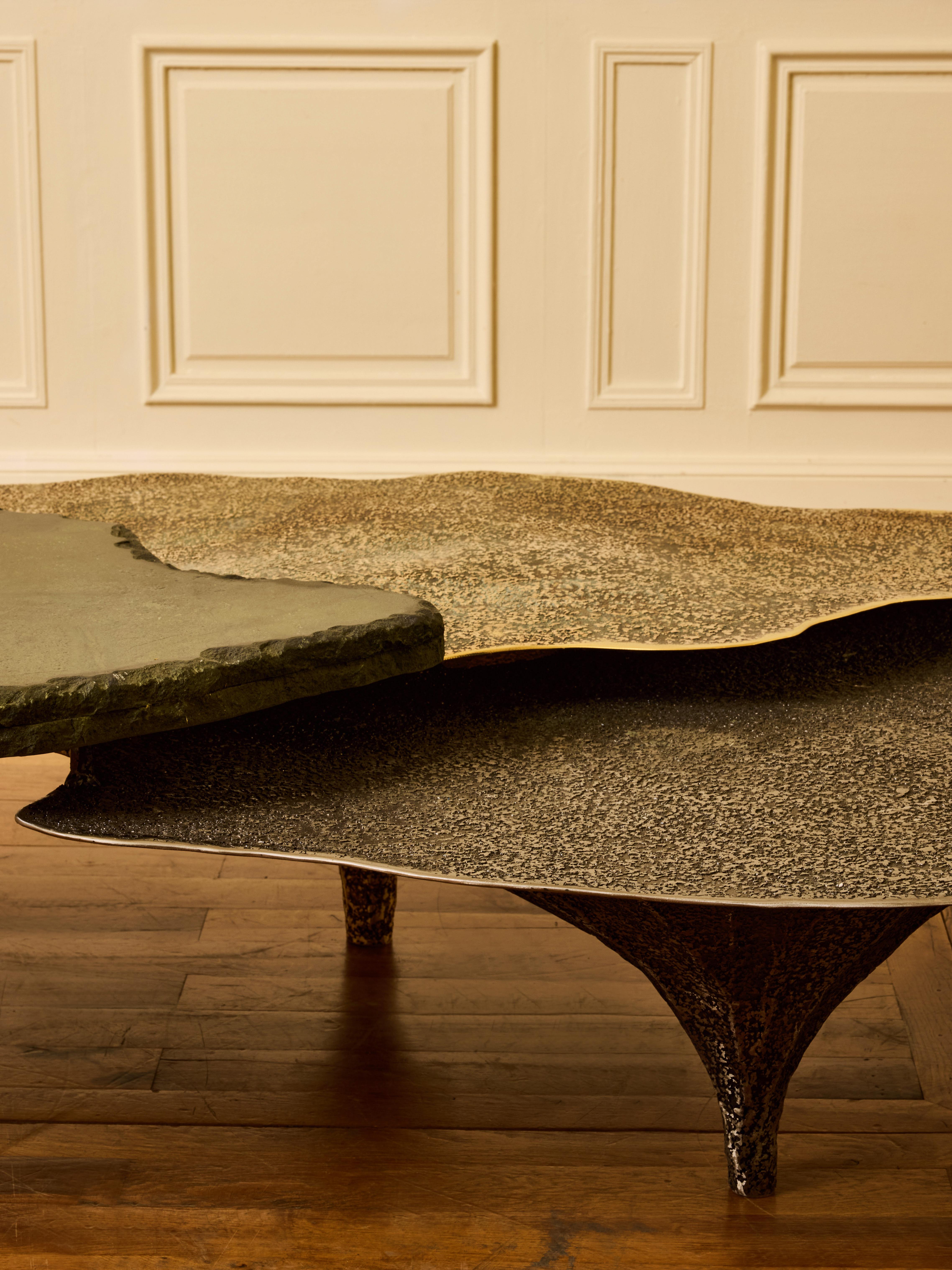 Table basse en marbre vert, acier patiné et laiton patiné.
Pièce unique et signée par l'artiste CHANEL KAPITAJN en Collaboration avec la Galerie Glustin
Belgique, 2025.