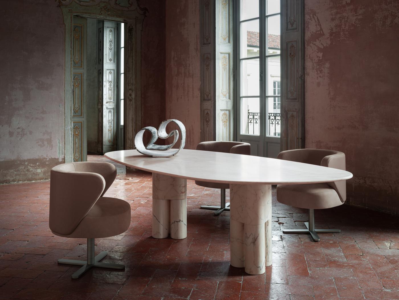 Raffinée et contemporaine dans sa distribution de volumes sculpturaux, cette table de salle à manger en marbre Pink Portugal prisé distille une opulence raffinée. Un couple de pieds d'inspiration zoomorphe soutient le large plateau, dont la forme