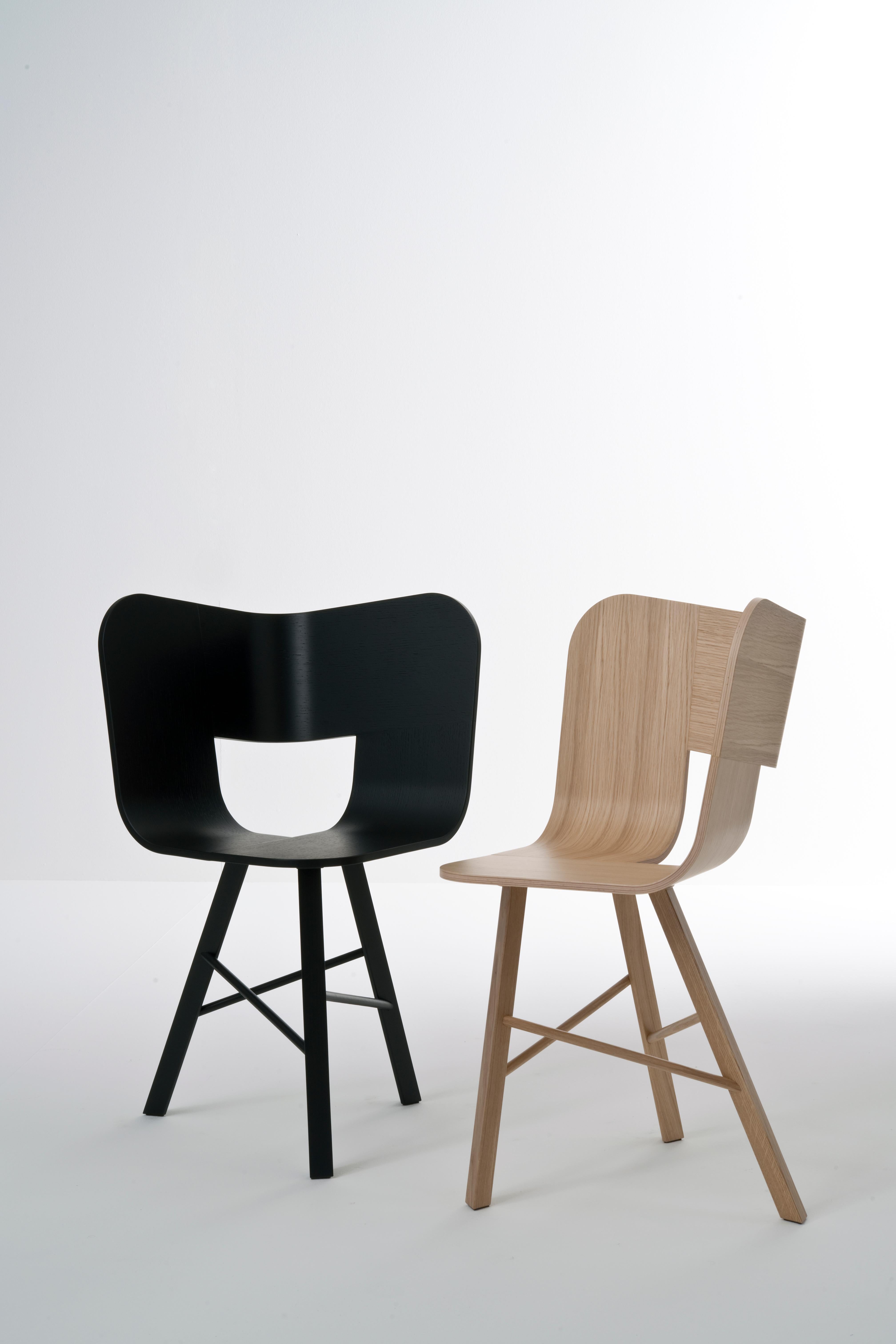 Tria wood chair is the icon of our collection. It's a table chair, but many people use it as a sculpture for the ambience, in an entrance, a bedroom, in a living room, or in any corner of the house. It recalls the impossible forms of Dutch graphic