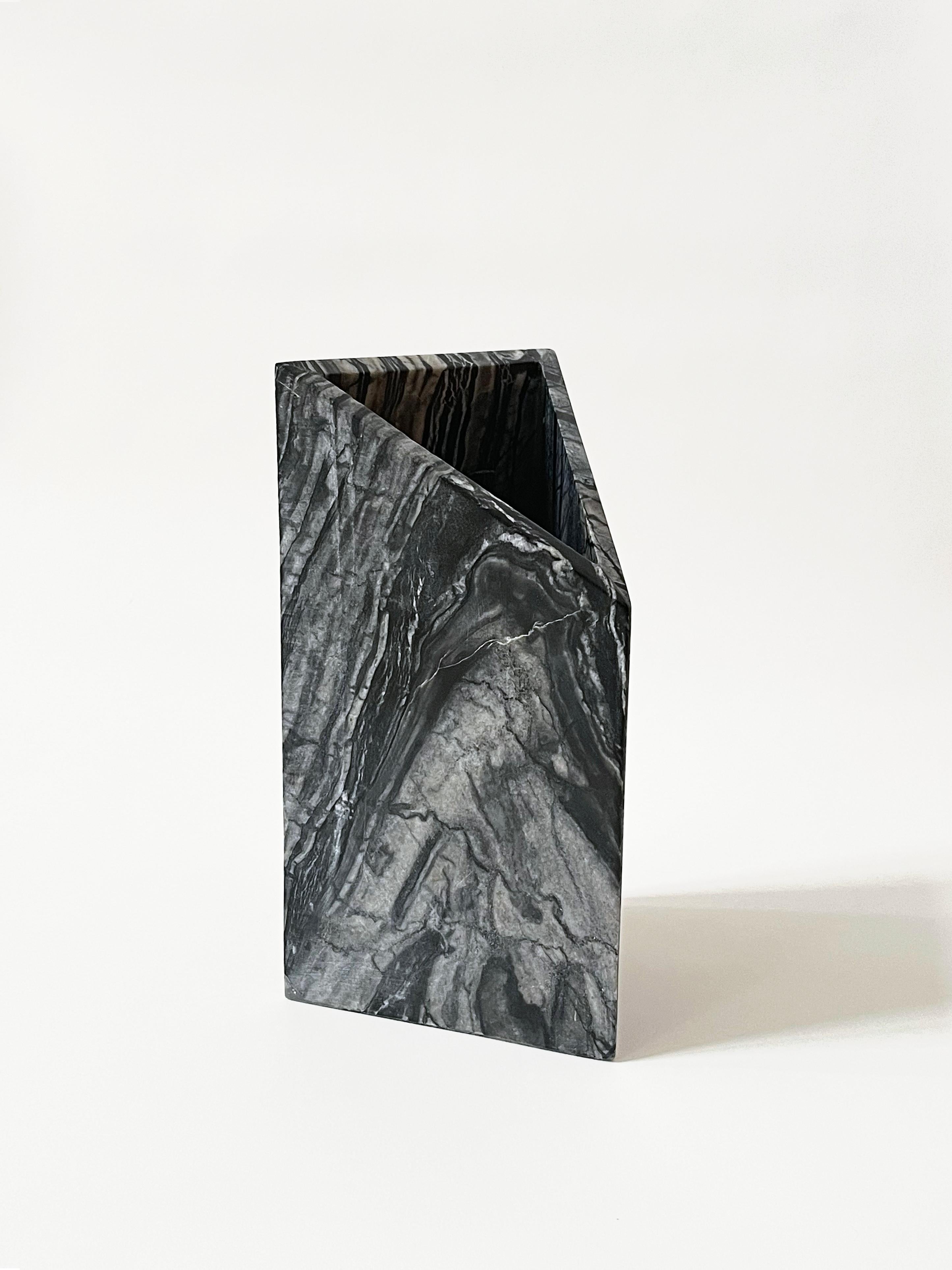 The Triad Vase was inspired by the natural patterns of Black Kenya marble. The vase balances texture and form through a subtle combination of geometry and meticulous grain matching. Each vase is handcrafted. The vase shown is the actual item being