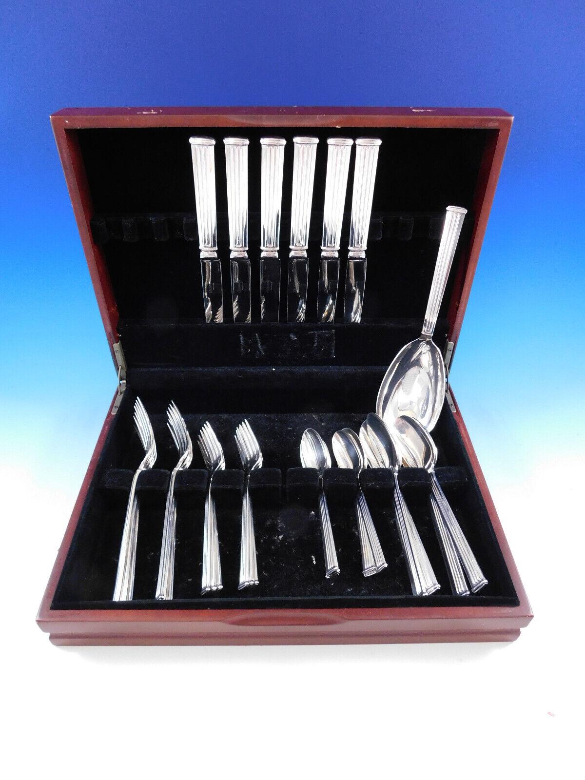 Des lignes modernes et épurées dans un motif de colonne classique rendent ce motif, Triade, indémodable. 
Service de couverts en argent Triade by Christofle France - 31 pièces. Cet ensemble comprend :

6 Couteaux de table, 9 3/4
6 Fourchettes à