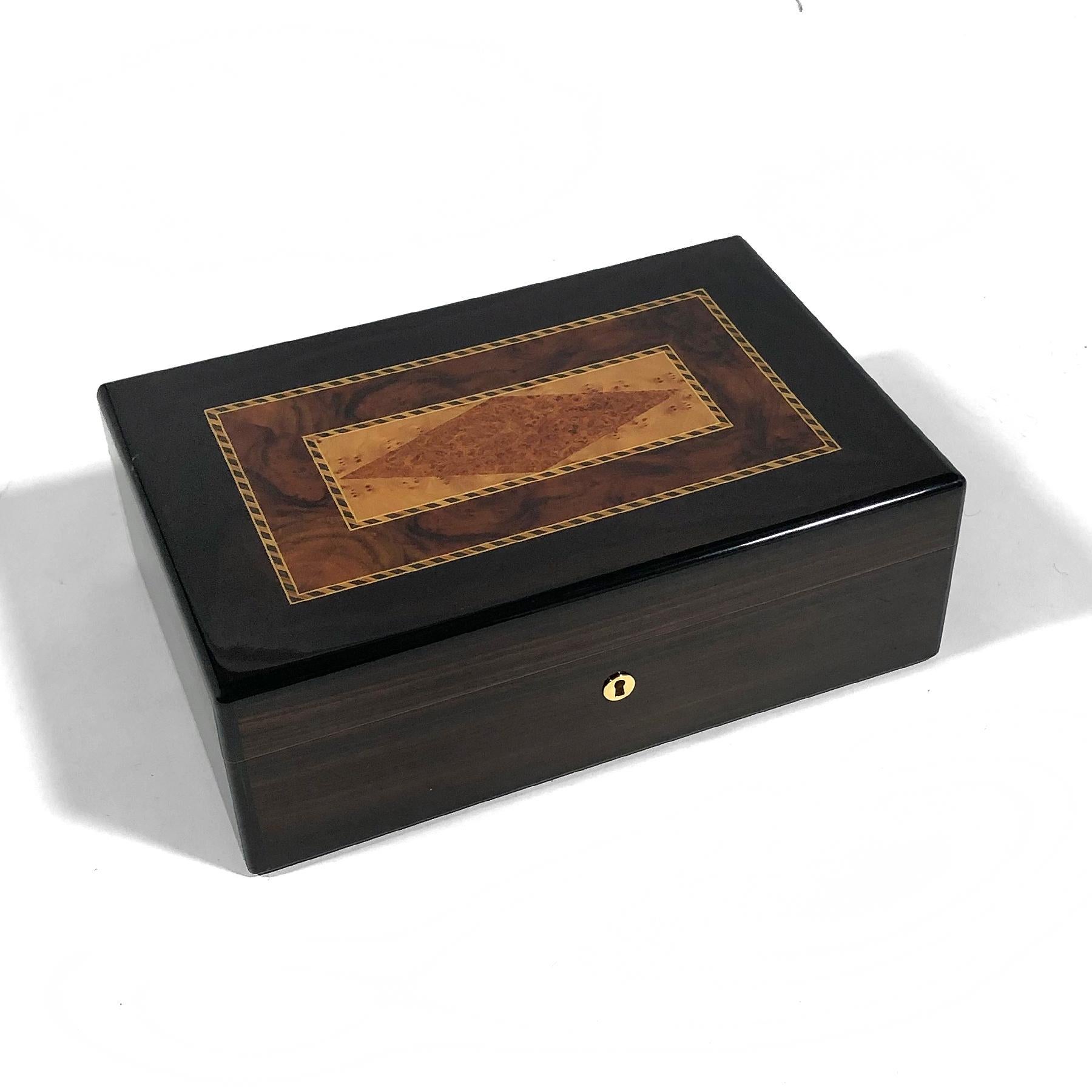This handsome mahogany humidor made in France by Triade has a beautiful marquetry top made of a variety of woods including highly figured burl.
