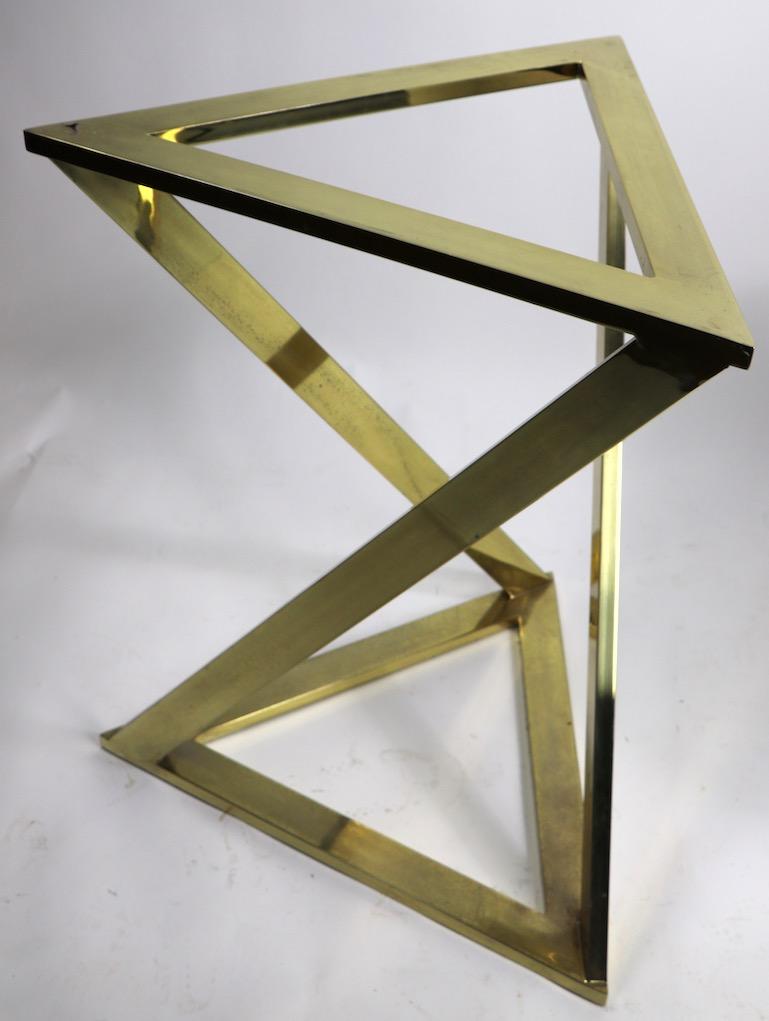 Stylish triangle brass plated table with thick beveled plate glass top, design attributed to Milo Baughman for Design Institute of America. The triangular base supports a .50 in glass top with a 1 inch beveled edge. The base shows minor wear to the