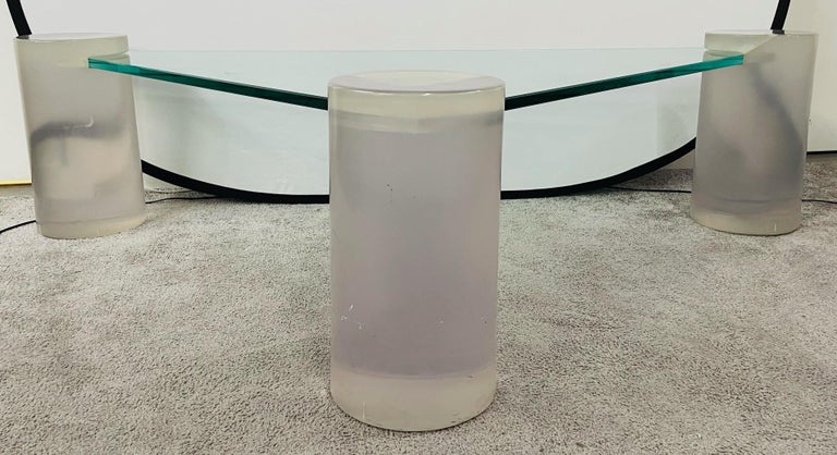 A stylish and timeless triangle glass top and Lucite coffee table in the manner of Karl Springer. . Each cylindrical corner is made of thick Lucite in a light purple tone. The top glass is inserted and supported by the three Lucite feet/ corners.
