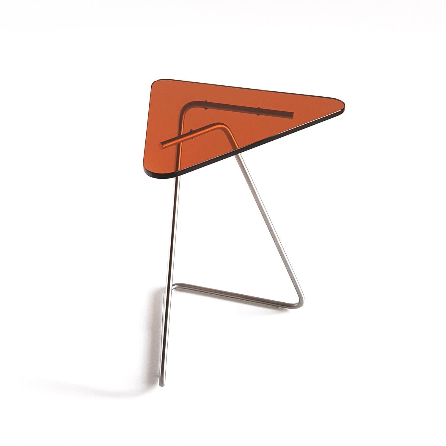 The triangle side table by Rita Kettaneh 
Dimensions: The base: brushed stainless steel 
 optionally plated with copper or brass
 The top: acrylic
Materials: H 49.5 x W 41 x D 9.5 cm
Weight: 2.6 Kg

Colors and finishes: 
Stainless finish: