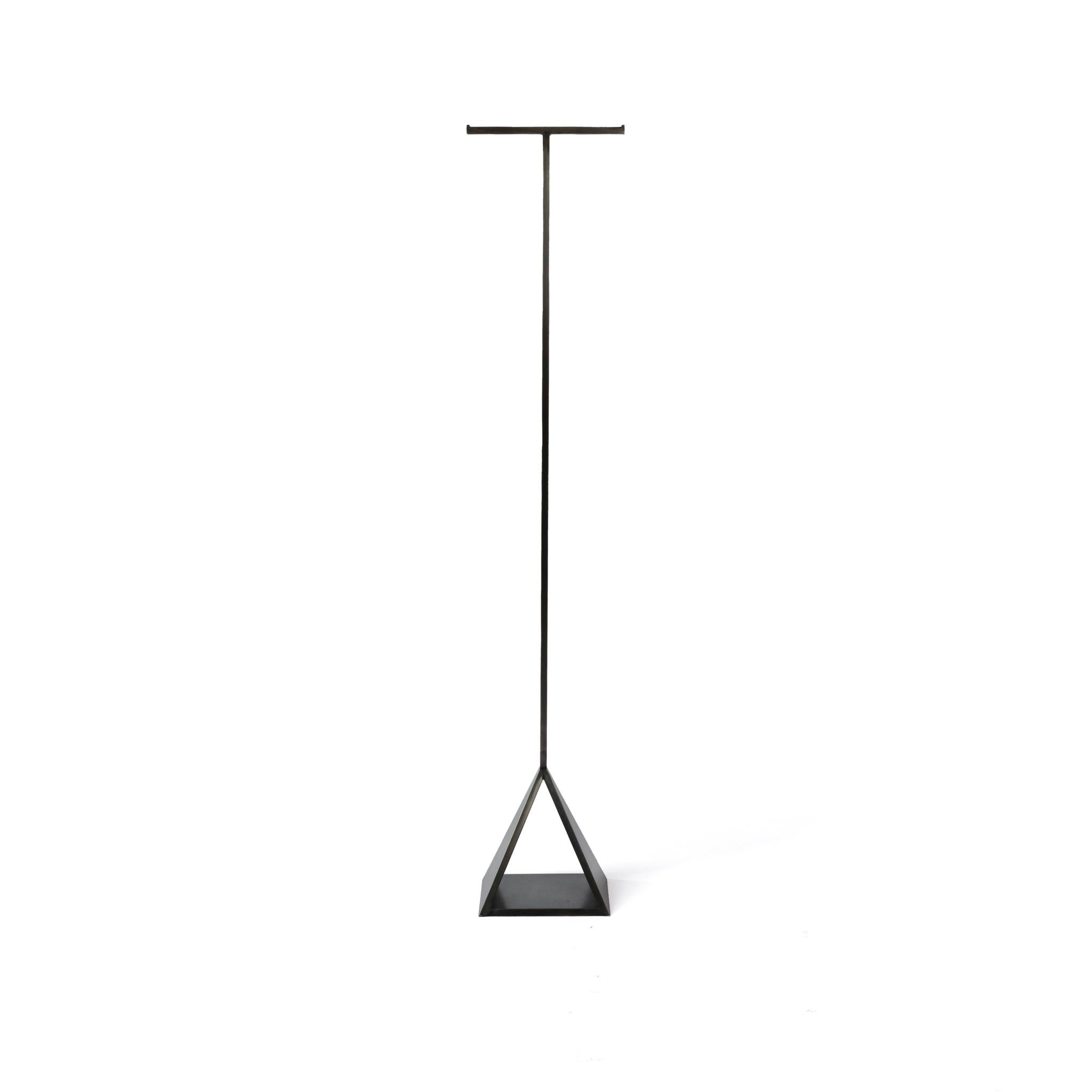 The Pyramid rack is a simple yet sturdy metal coat hanging rack with smooth edges and in a blackened steel hand finish. The use of half inch square bar to create the T-bar and open triangular base create a modern and sleek minimal design. It can be