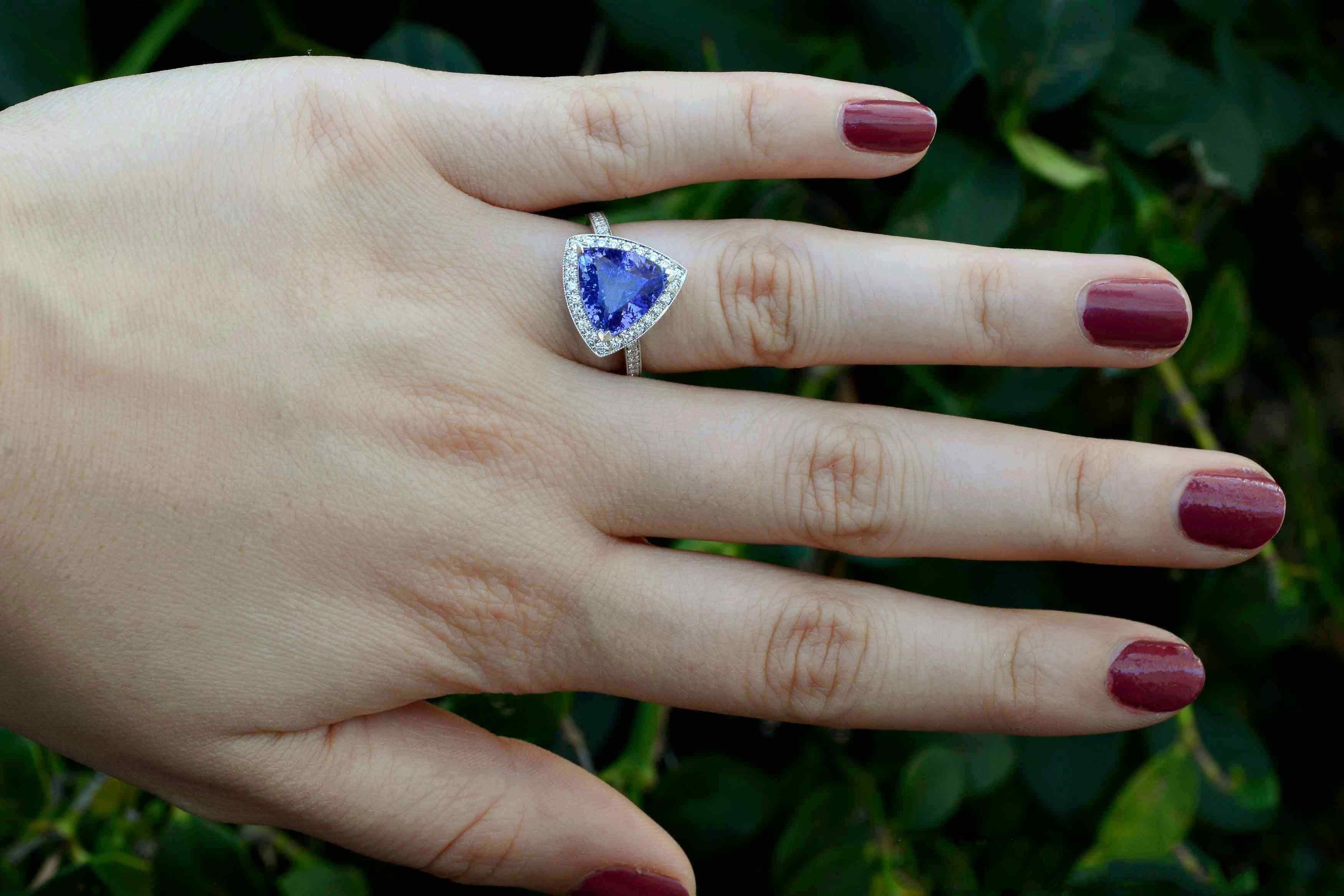 The Oceanside tanzanite engagement ring. Taking center stage is a velvety violet-blue triangle cut tanzanite of 3.60 carats, surrounded by a glimmering diamond halo and band. You'll love the cool angles and cut of the gem and the delicate millgrain