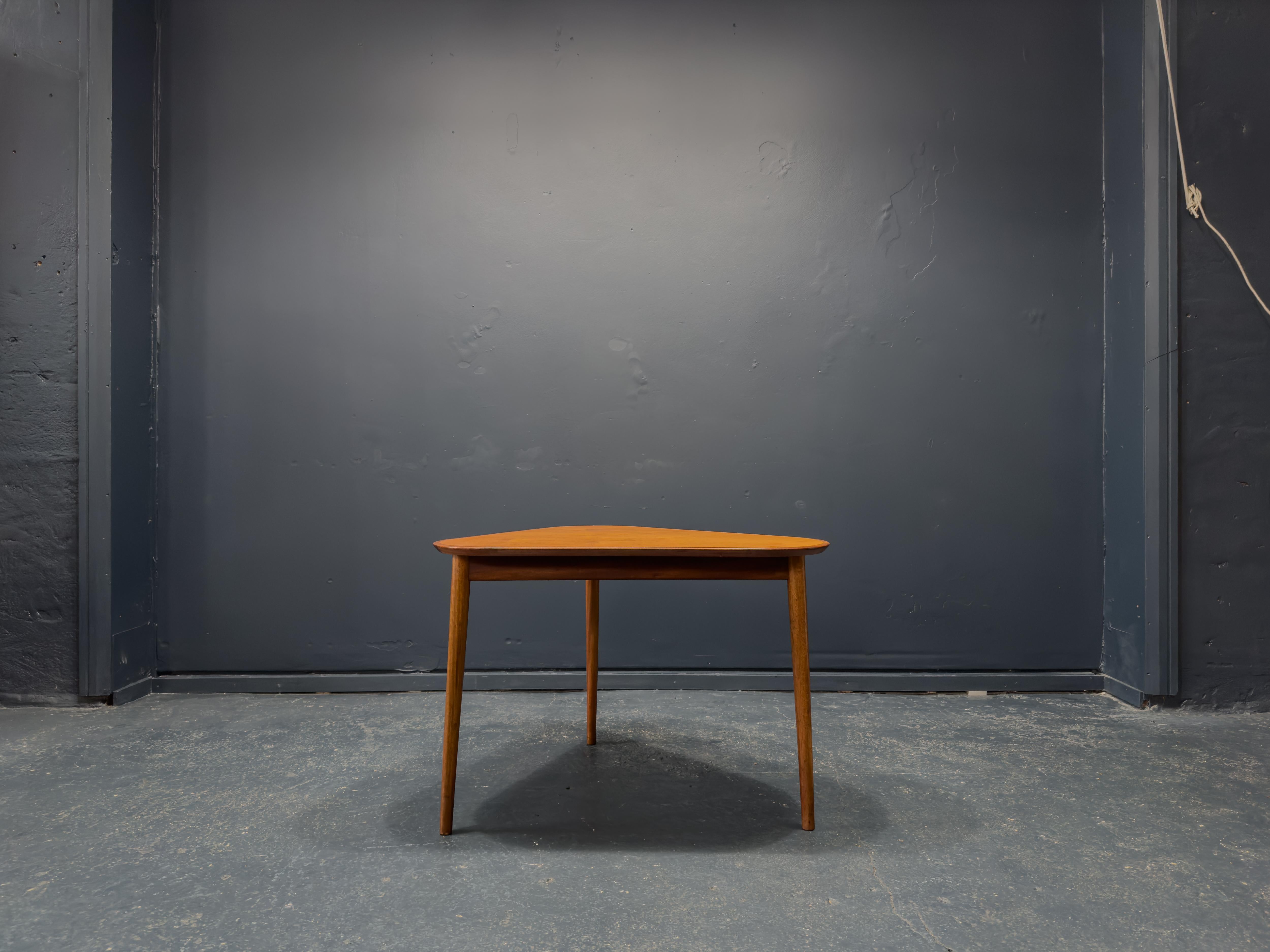 Cette table d'appoint compacte est une excellente pièce. Avec sa forme triangulaire, elle s'intègre parfaitement dans n'importe quel espace. Les détails des arêtes du plateau de la table, réalisés par des experts, témoignent du temps et de la