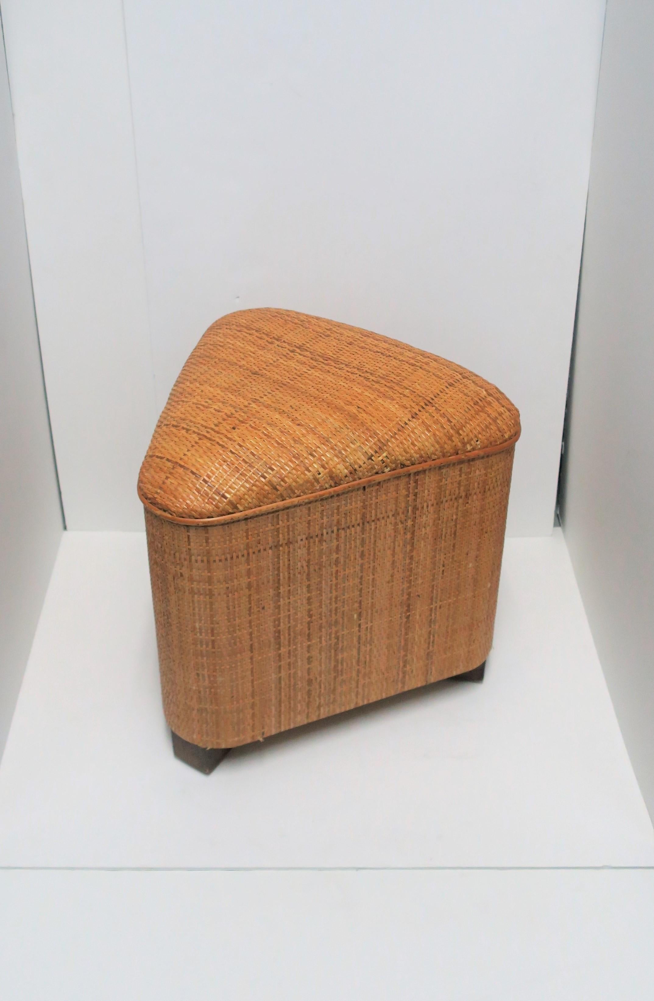 This is a small and convenient geometric or 'triangle' wicker seat/bench/stool, circa early 21st century. Piece may even be used as a side table providing there is a stabile environment on top for support, i.e., book, tray, etc., (demonstrated in