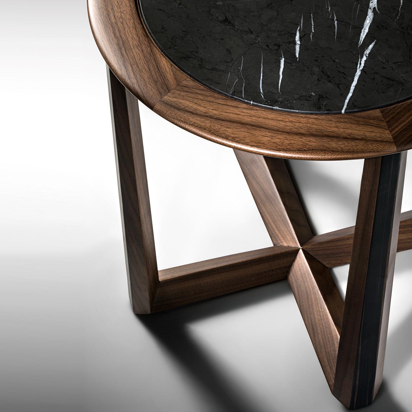 Cette table d'appoint prisée offre un exemple sophistiqué de style de mobilier intemporel, mettant en valeur le travail exceptionnel du designer Ivano Colombo. Fabriquée en noyer Canaletto massif, sa silhouette se caractérise par un plateau rond et