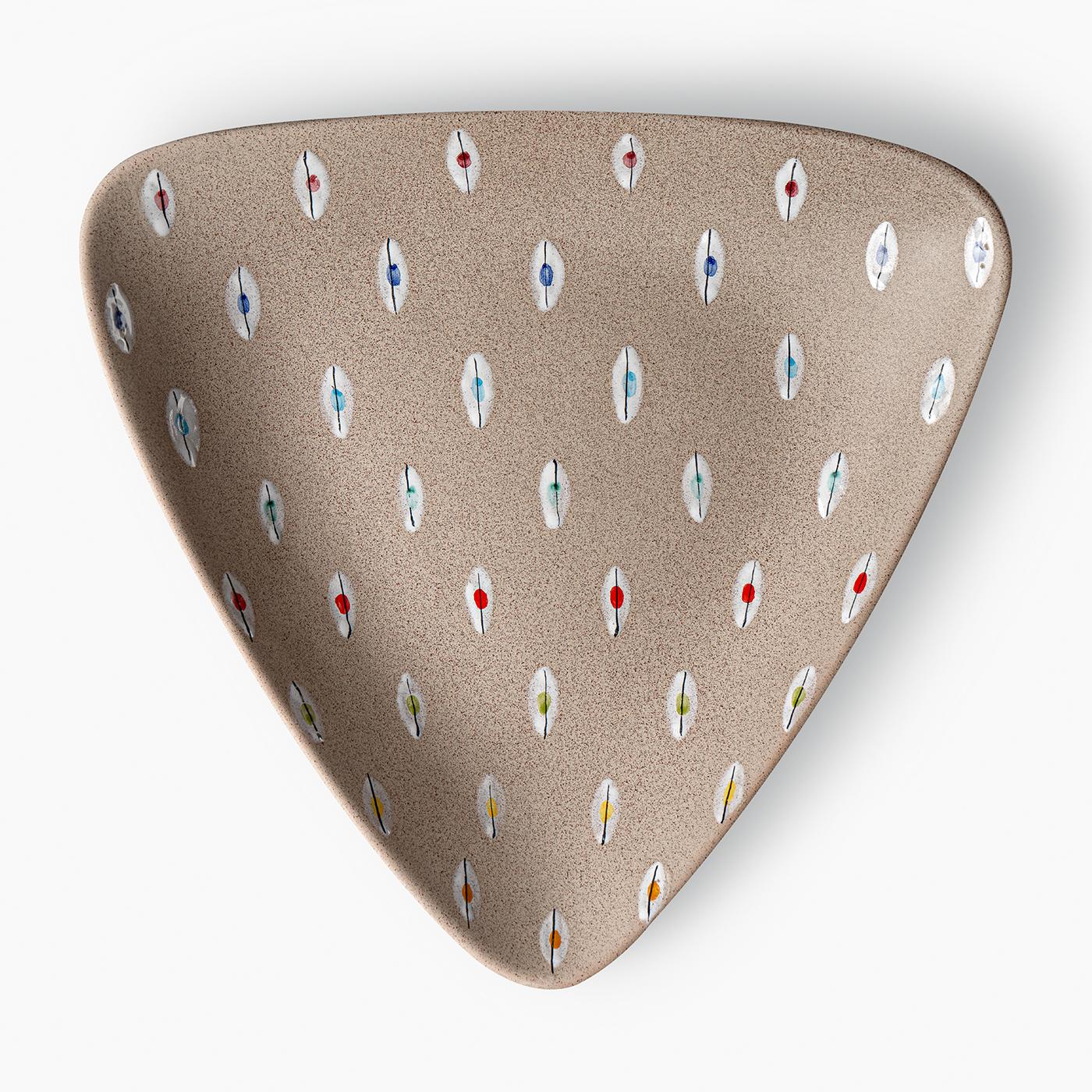 This triangular centerpiece features a press-molded terra cotta form with a finely speckled gray base. The surface is decorated with an array of small, brush-painted white motifs accented in varied colors, reminiscent of multicolored feathers or