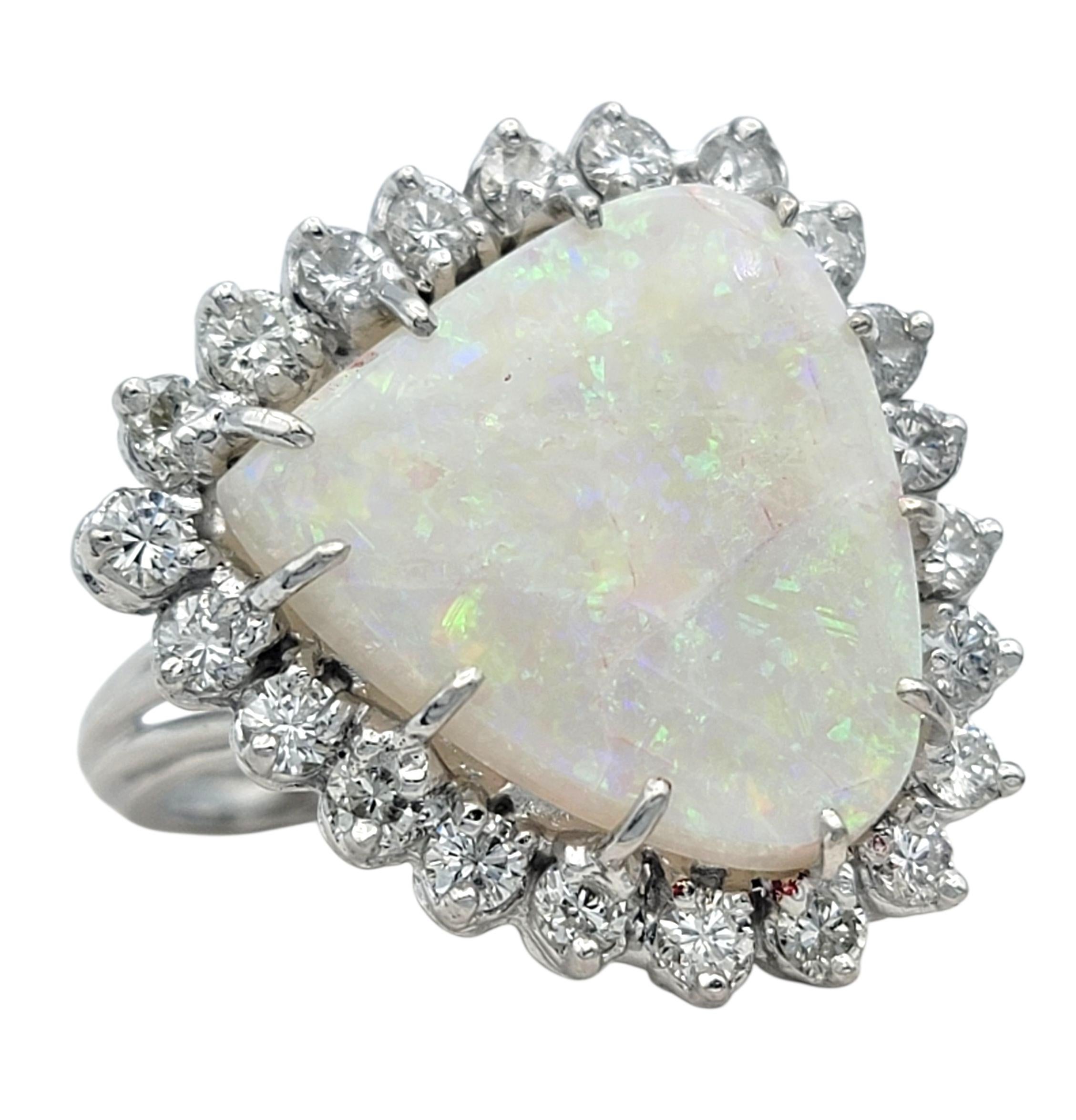 Dieser Opal- und Diamantring ist ein fesselnder Ausdruck von Farbe und Licht und besticht durch seine ätherische Schönheit. In seinem Zentrum glüht ein leuchtender Opal, der in rosa, grünen und blauen Tönen schillert und sich mit jedem Blickwinkel