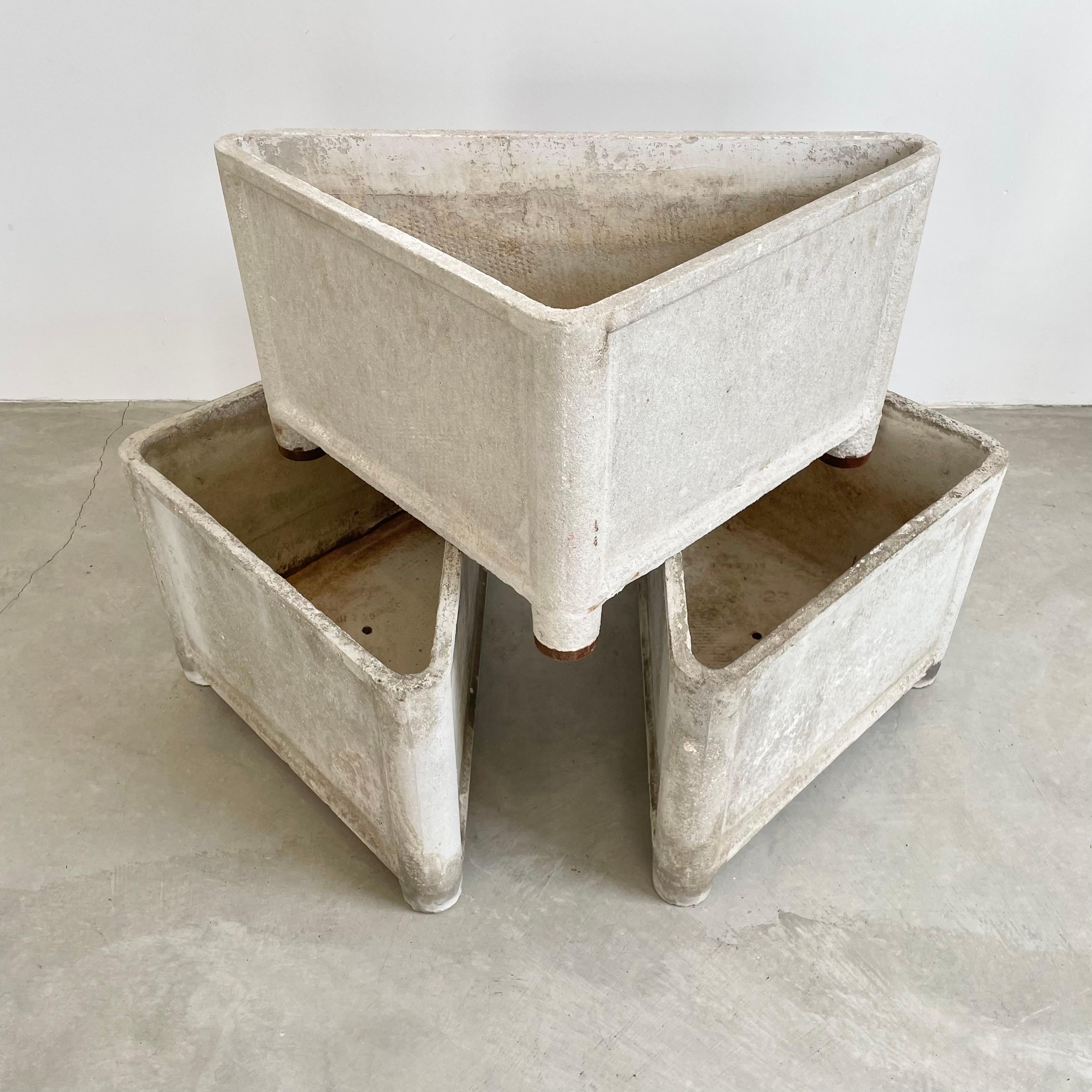 Sculptural triangular concrete planters by Swiss Architect Willy Guhl. Each planter has a concrete leg at each corner of the planter which allows the planter to float a couple of inches above the ground. All pieces dated, and marked with factory
