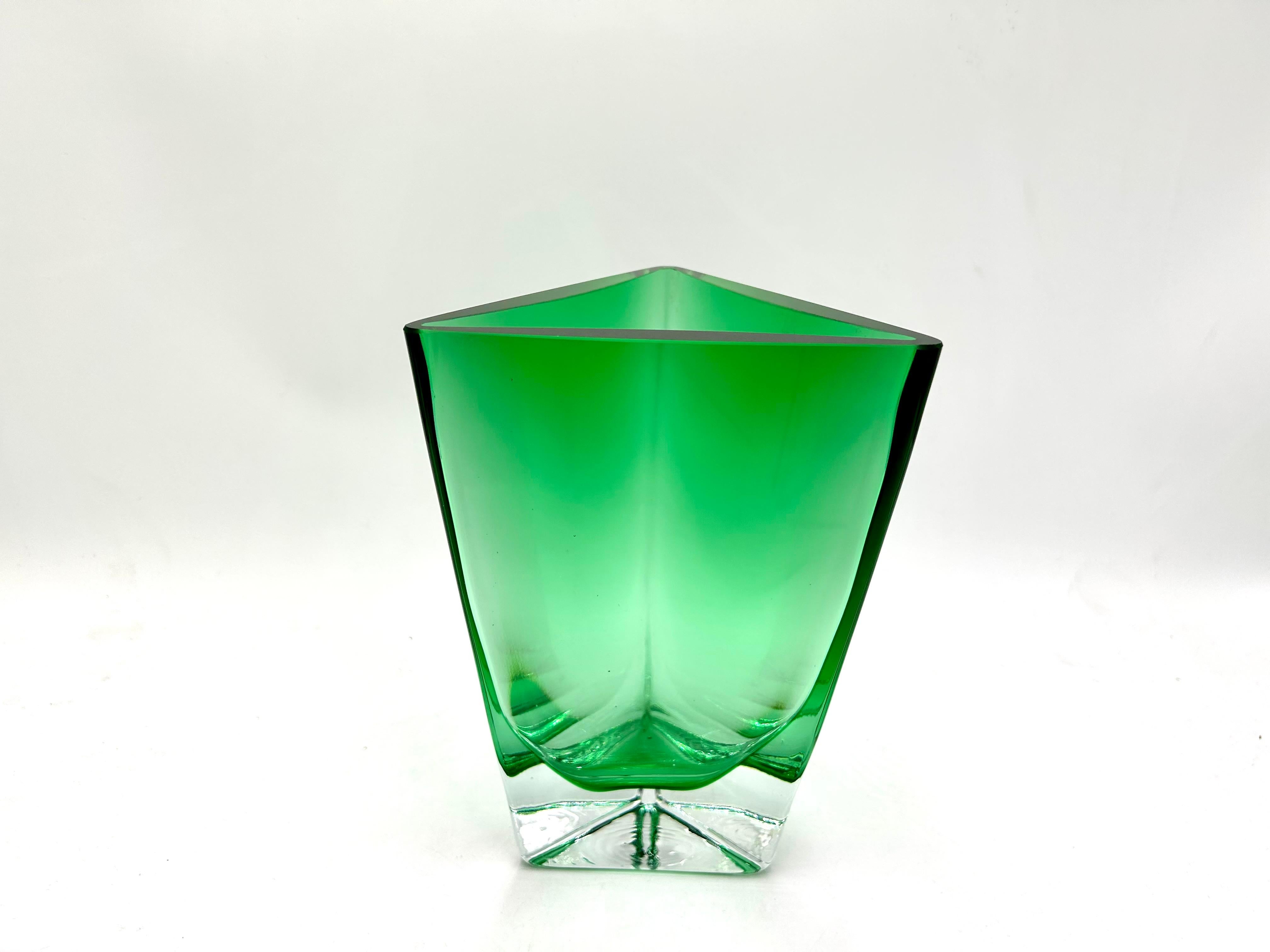 Beautiful emerald vase with a triangular shape.

Solid thick green glass on a transparent base.

Produced by Huta Szkla Krosno in the 1990s

Measures: height: 21.5

width: 15cm.