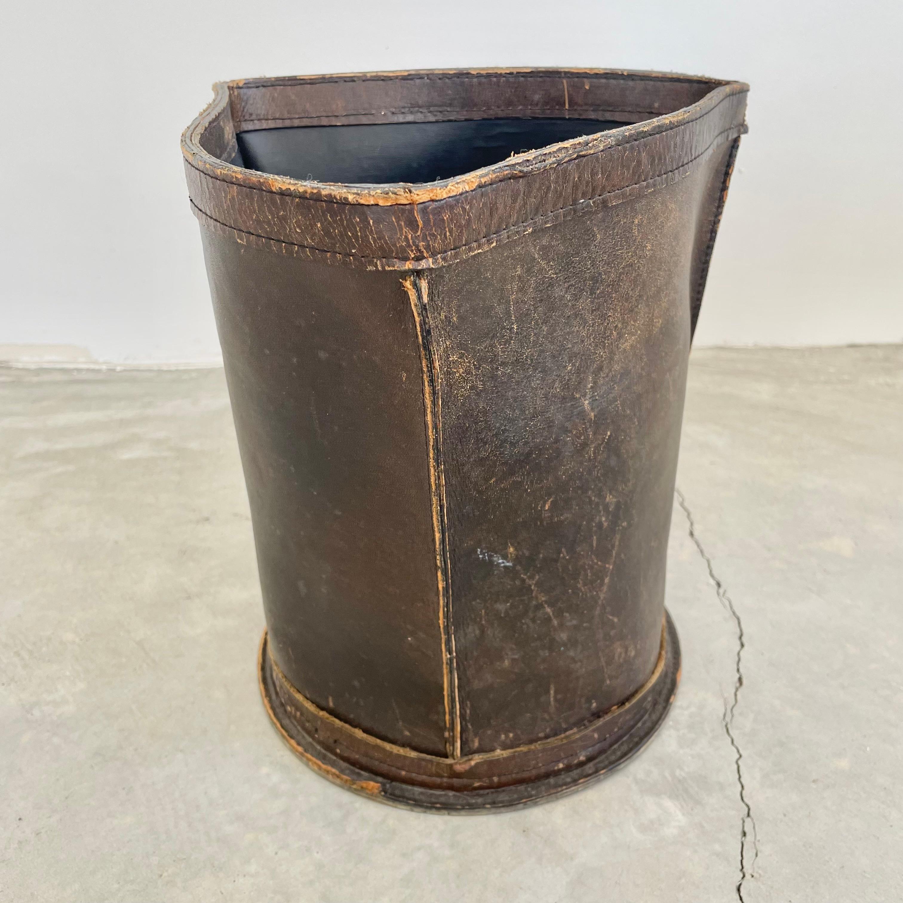 Beautiful distressed leather waste bin. Fully made of a thick chocolate brown leather. Triangular shape on a circular base giving it unique lines. Great patina from years of use. High quality leather that just gets better with age.