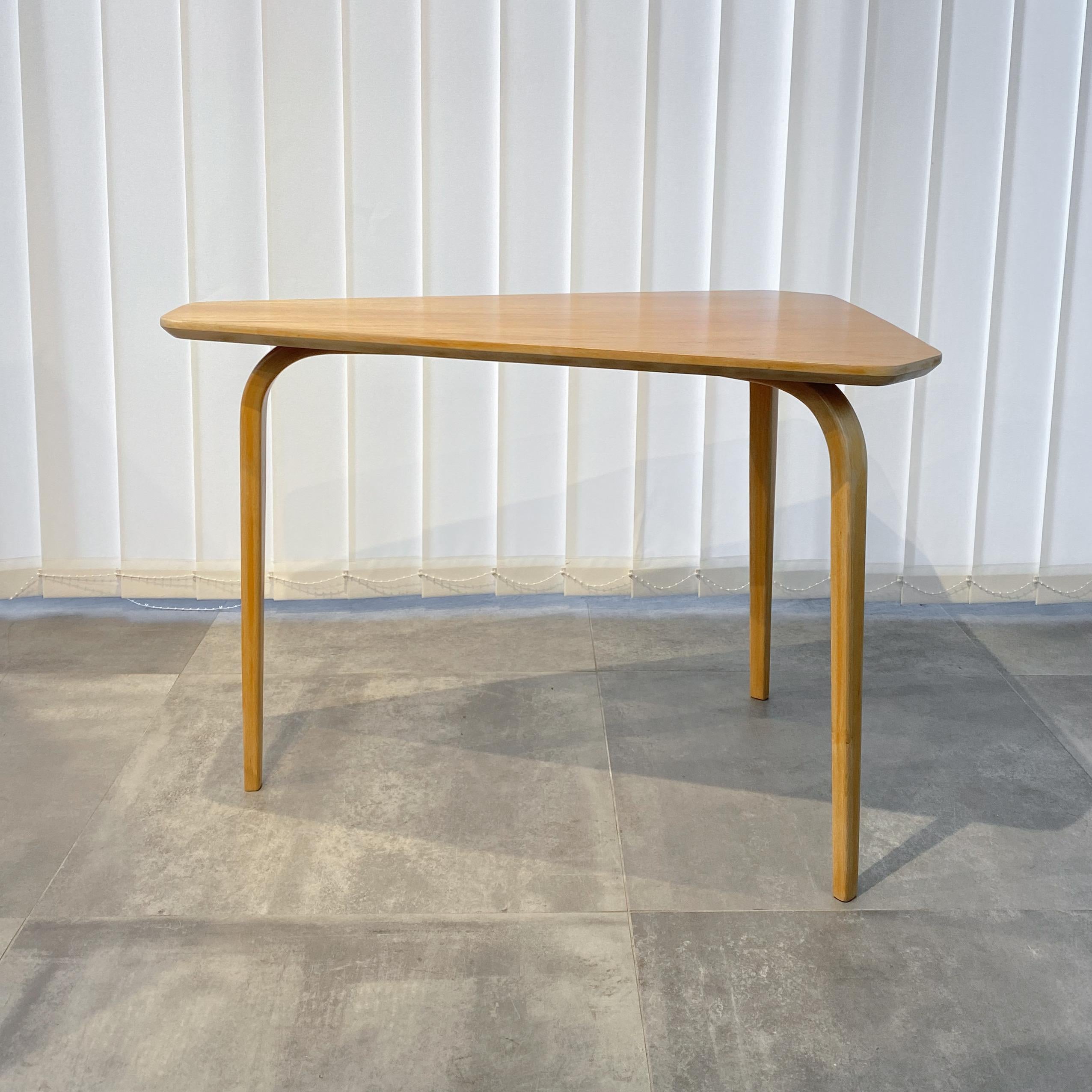 Swedish functionalist coffee table with a triangular tabletop resting on three bentwood legs. The legs are made from solid beech, and the tabletop is covered in elm veneer. Produced by an unidentified Swedish manufacturer in the 1940s, following the