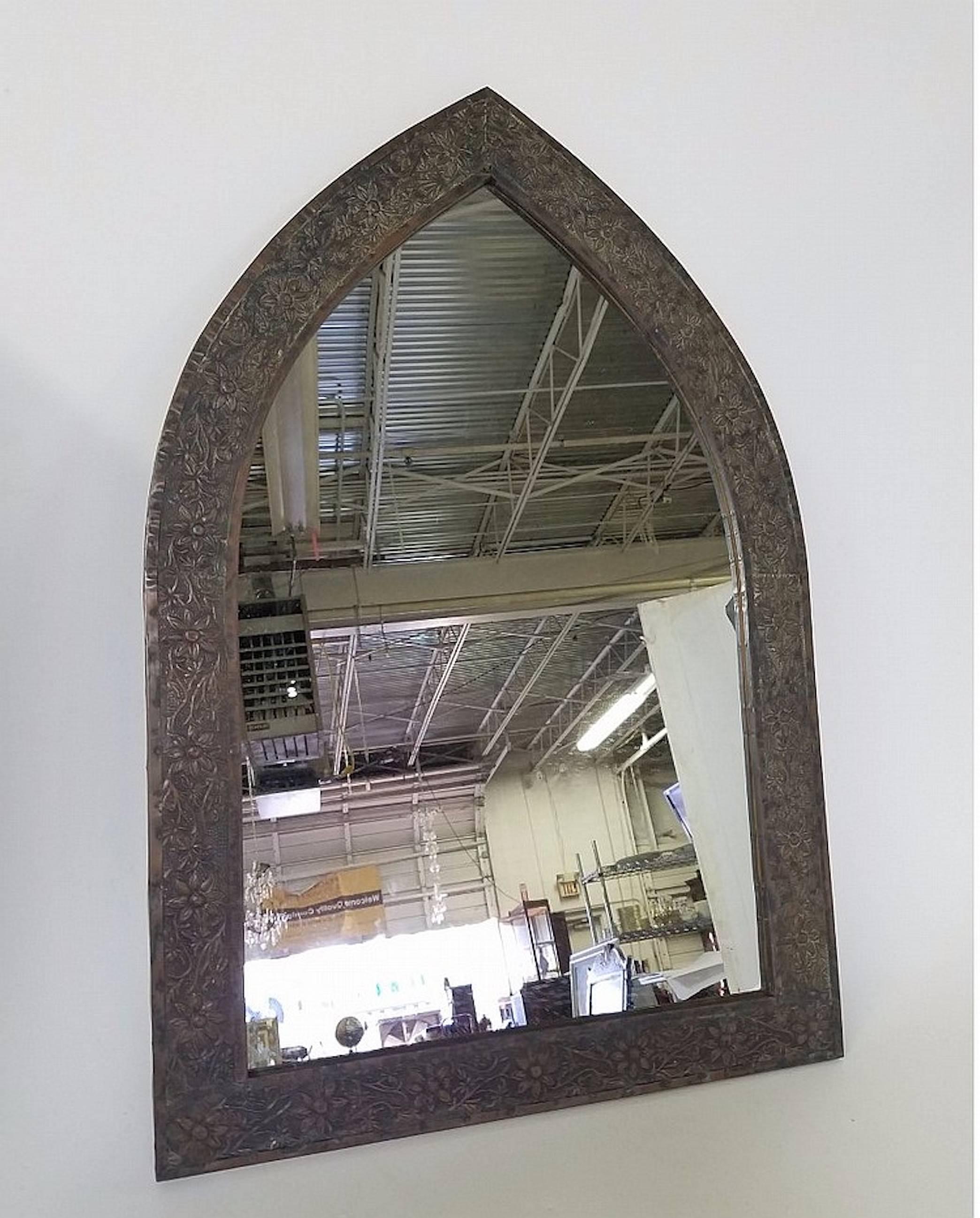 Triangular patinated tole Gothic style mirror, with chased floral motif surround.