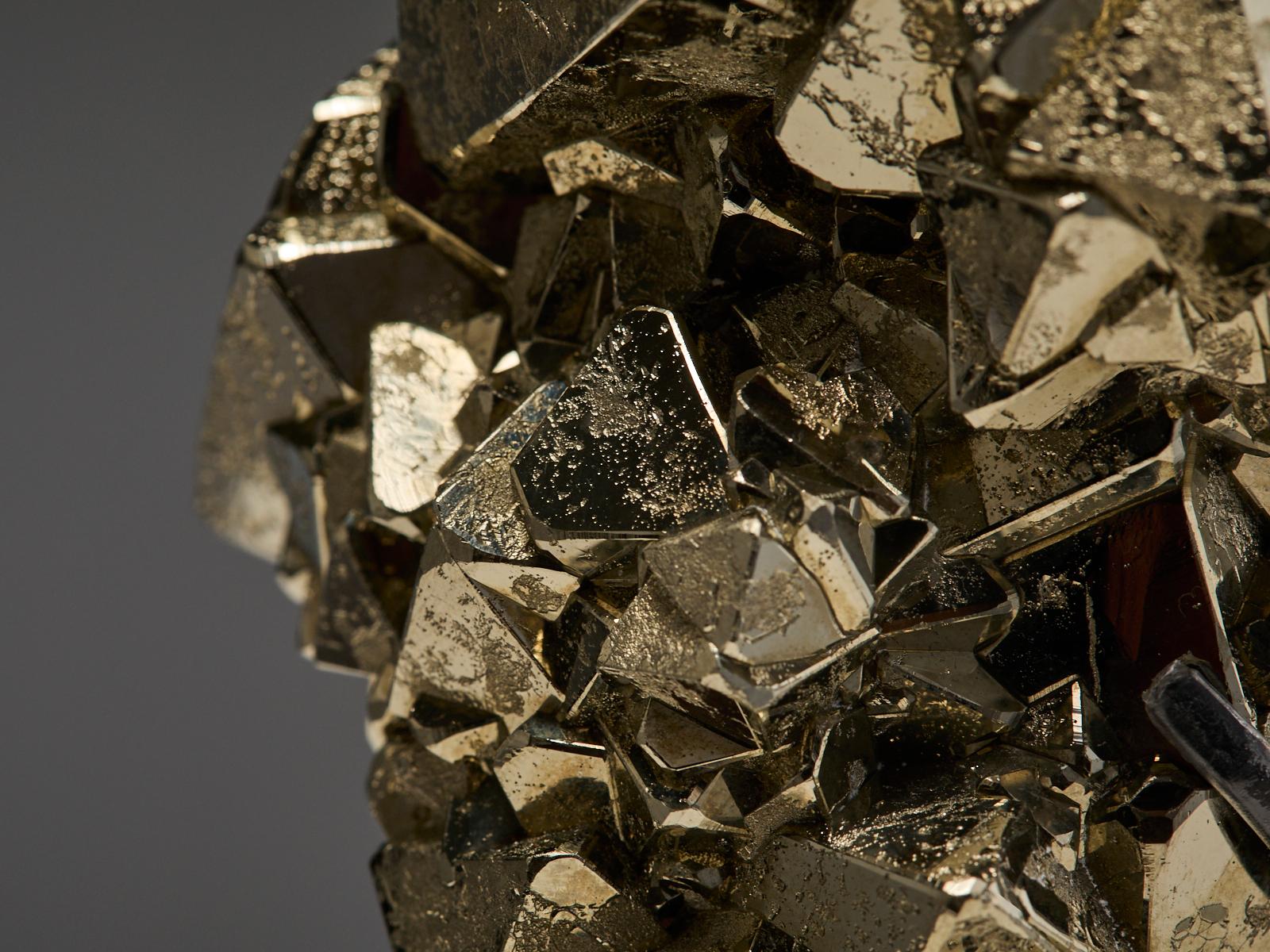 A striking specimen of pyrite with hematite from Peru, featuring sharp triangular crystals with a fascinating mix of textures. Some surfaces are smooth and reflective, while others are more matte and naturally porous, creating a beautiful contrast