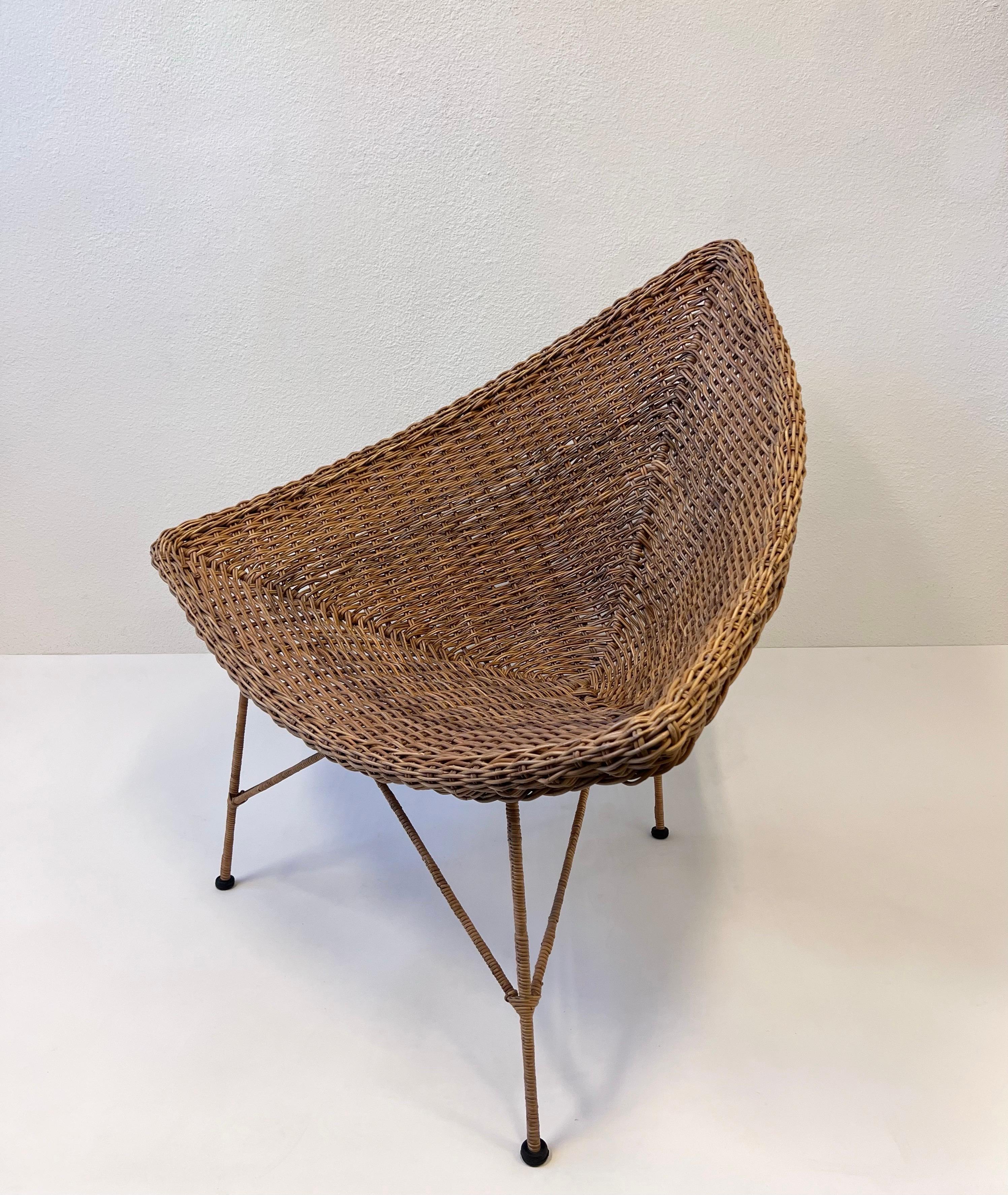 1970’s Triangular shape rattan lounge chair. 
Constructed of steel frame and woven rattan. 
In original condition shows minor wear consistent with age. 

Measurements: 41.5” Wide, 32.5” Deep, 39” High. 15.5” Seat. 