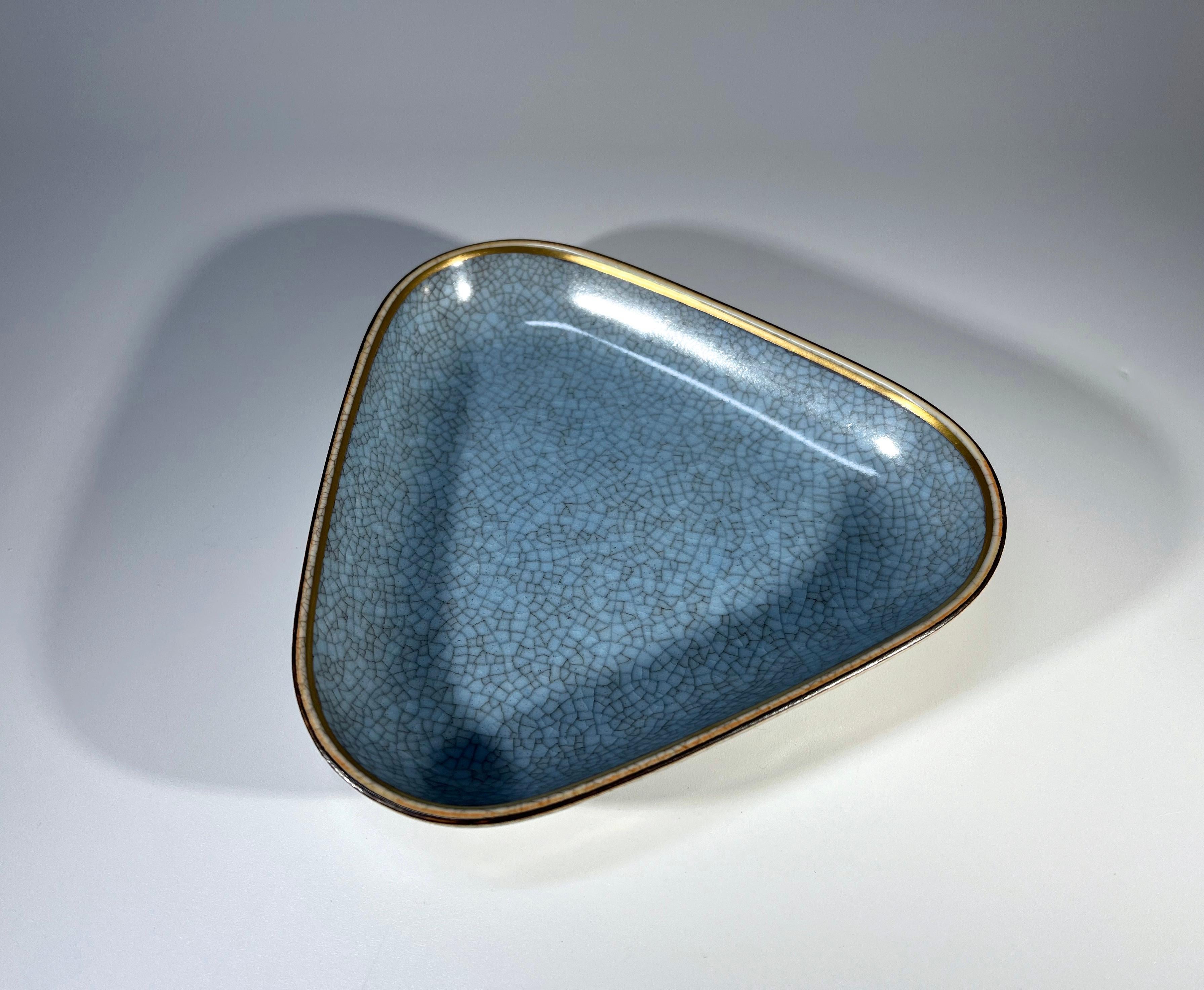 Plat à bibelots triangulaire en porcelaine très inhabituel de Royal Copenhagen, Danemark
Intérieur en glaçure craquelée bleu pâle, bord doré et extérieur en glaçure craquelée grise
Circa 1958
Estampillé et numéroté 4069
Hauteur 1 pouce, Largeur 5.25