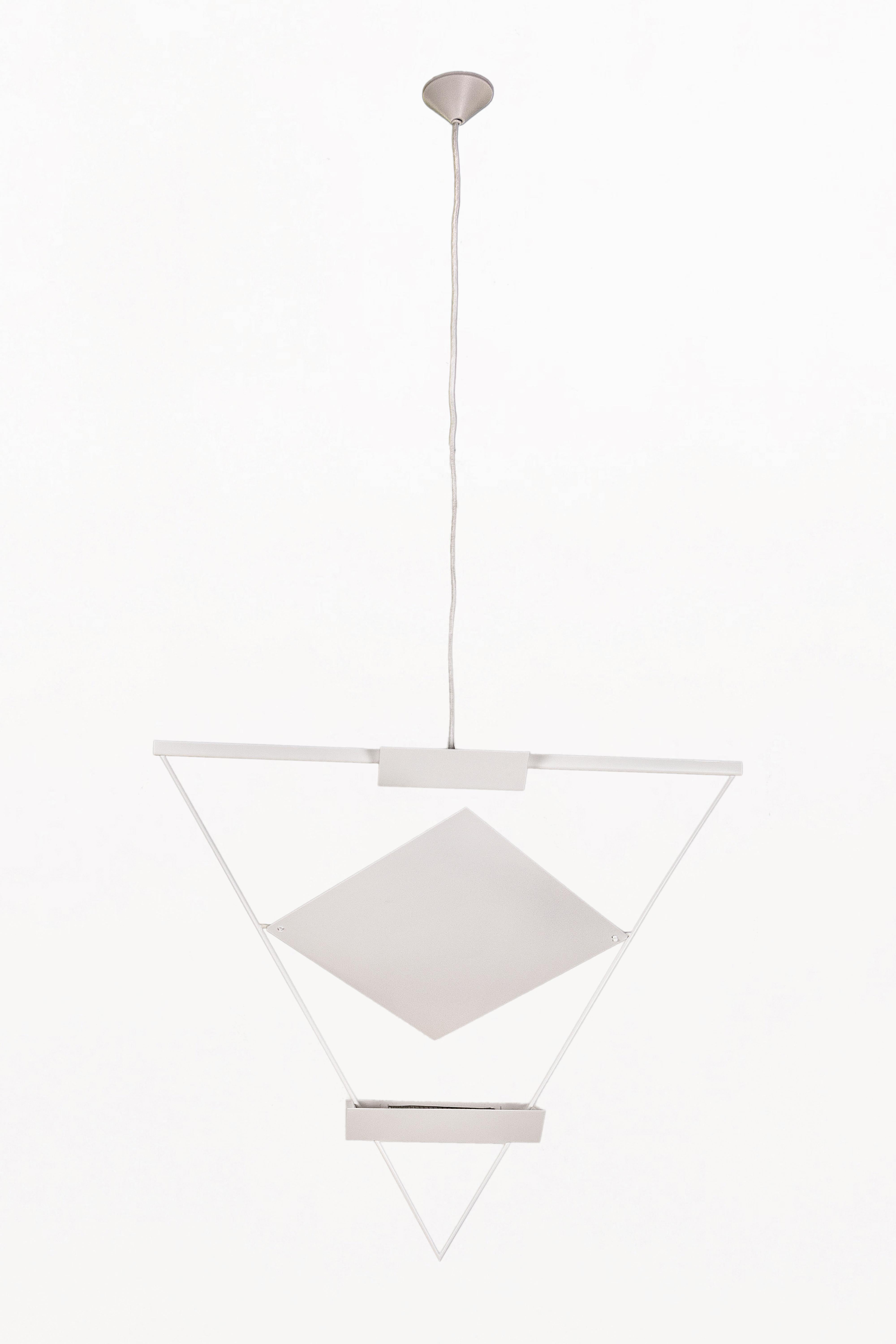 DESCRIZIONE: Ciondolo a sospensione triangolare di Mario Botta per Artemide, Circo 1980, Italia
Design/One.
Lampada a sospensione triangolare con struttura in metallo smaltato bianco,  2 sorgenti luminose e un pannello centrale orientabile per