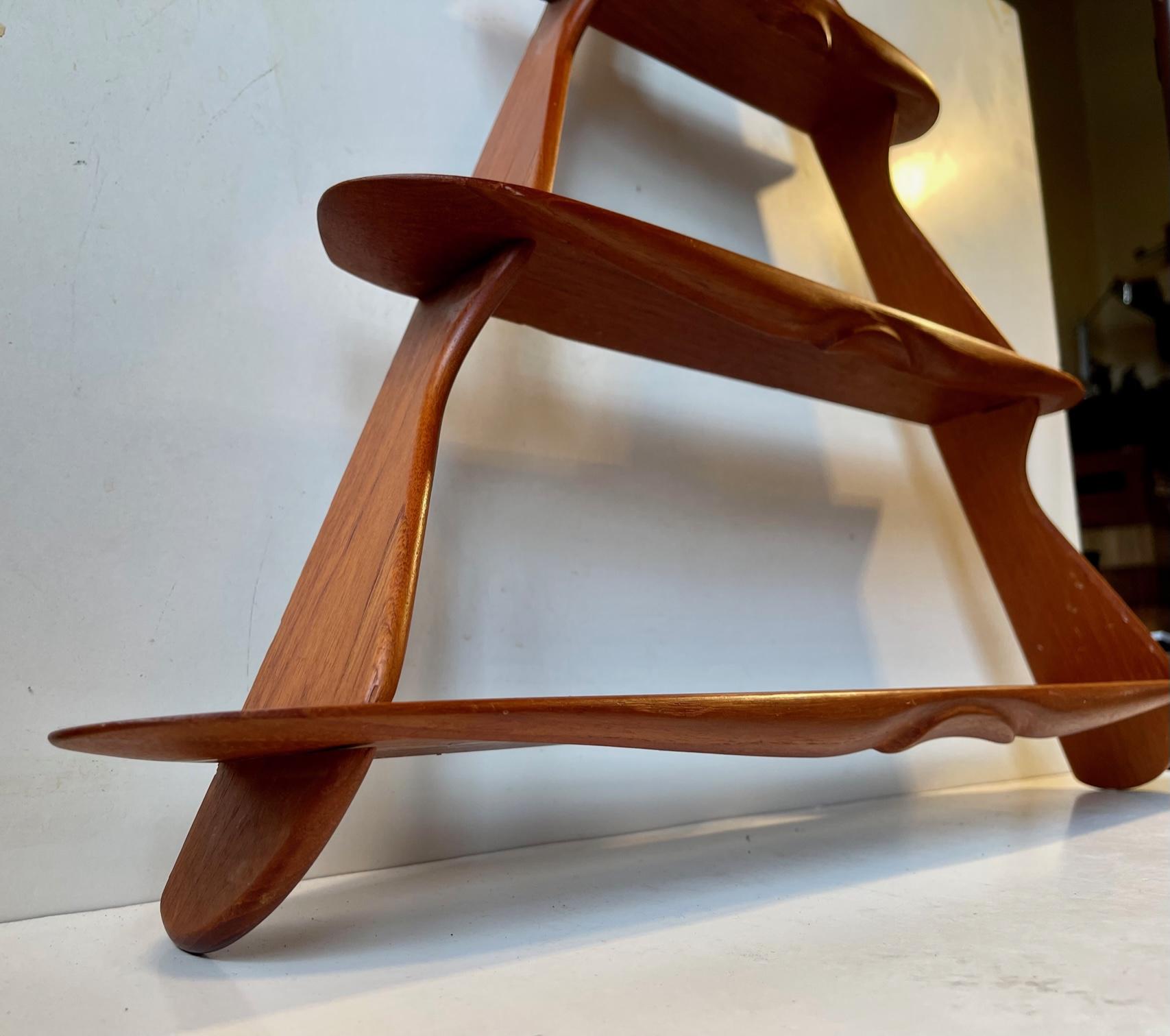Small triangular wall shelf in solid teak. Assembled without the use of metal. It can be disassembled and assembled again within minutes. It features beautiful organically shaped and hand-finished profiles. This design is attributed to the most