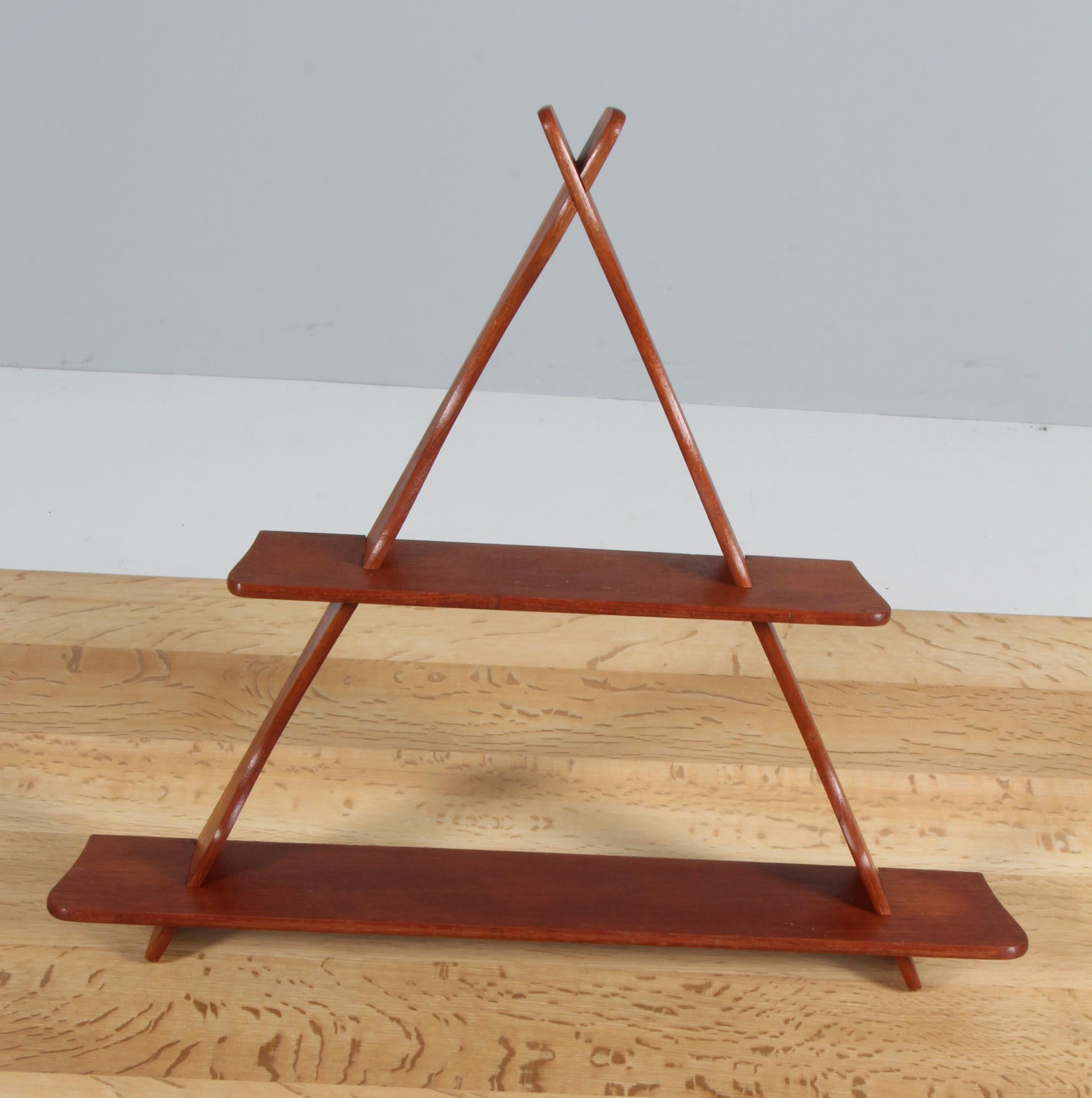 Small triangular wall shelf in solid teak. Assembled without the use of metal. It can be disassembled and assembled again within minutes. It features beautiful organically shaped and hand-finished profiles. This design is attributed to the most