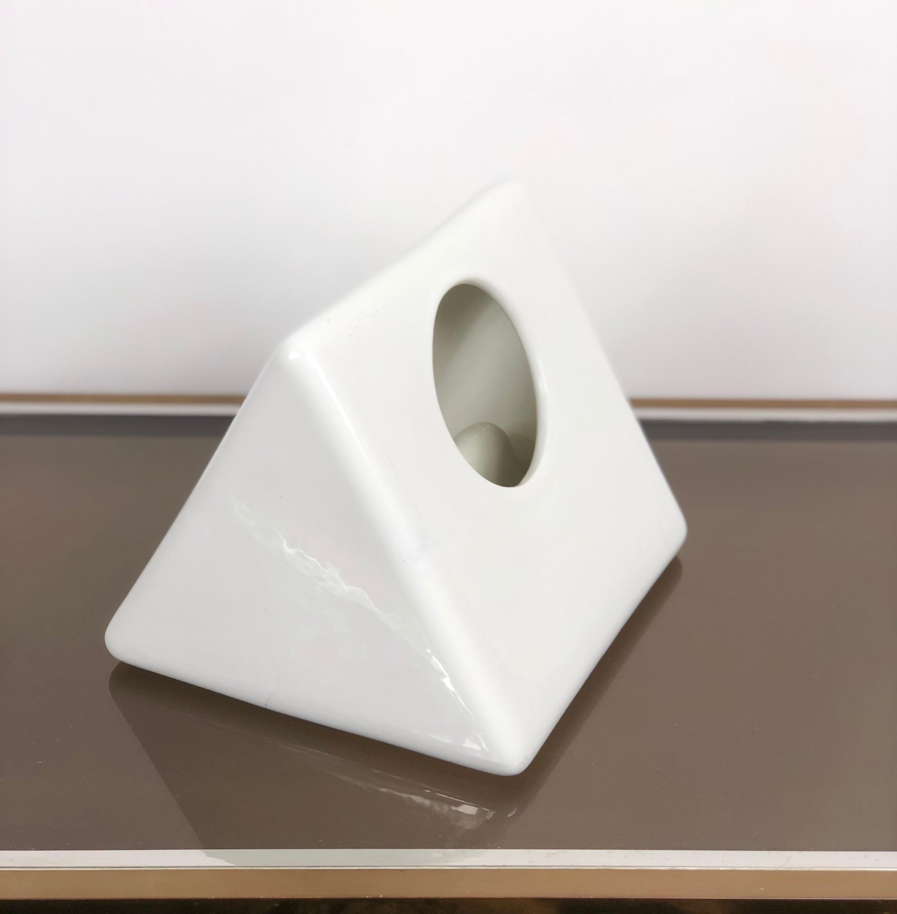 Particular triangular vase made of white ceramics by the Italian designer Gabbianelli during the 1970s. As the photos show, this wonderful item has two little grains on the bottom.