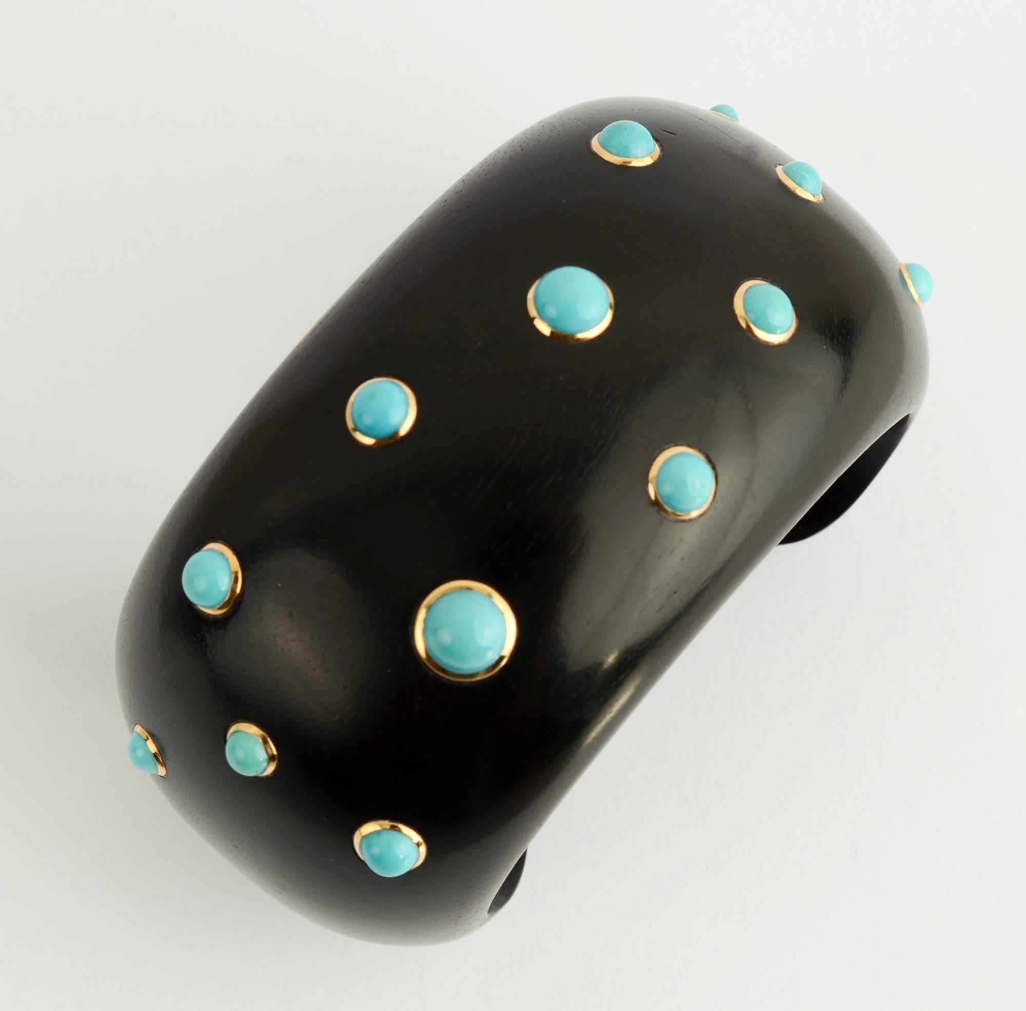Stunning ebony and turquoise cuff bracelet by Trianon. The turquoise stones are set in 18 karat gold.
The bracelet has an inside diameter of 2 1/4 inches with an opening of 1 1/4 inches.  It is 1 3/4 inches wide. The bracelet  fits a medium wrist.