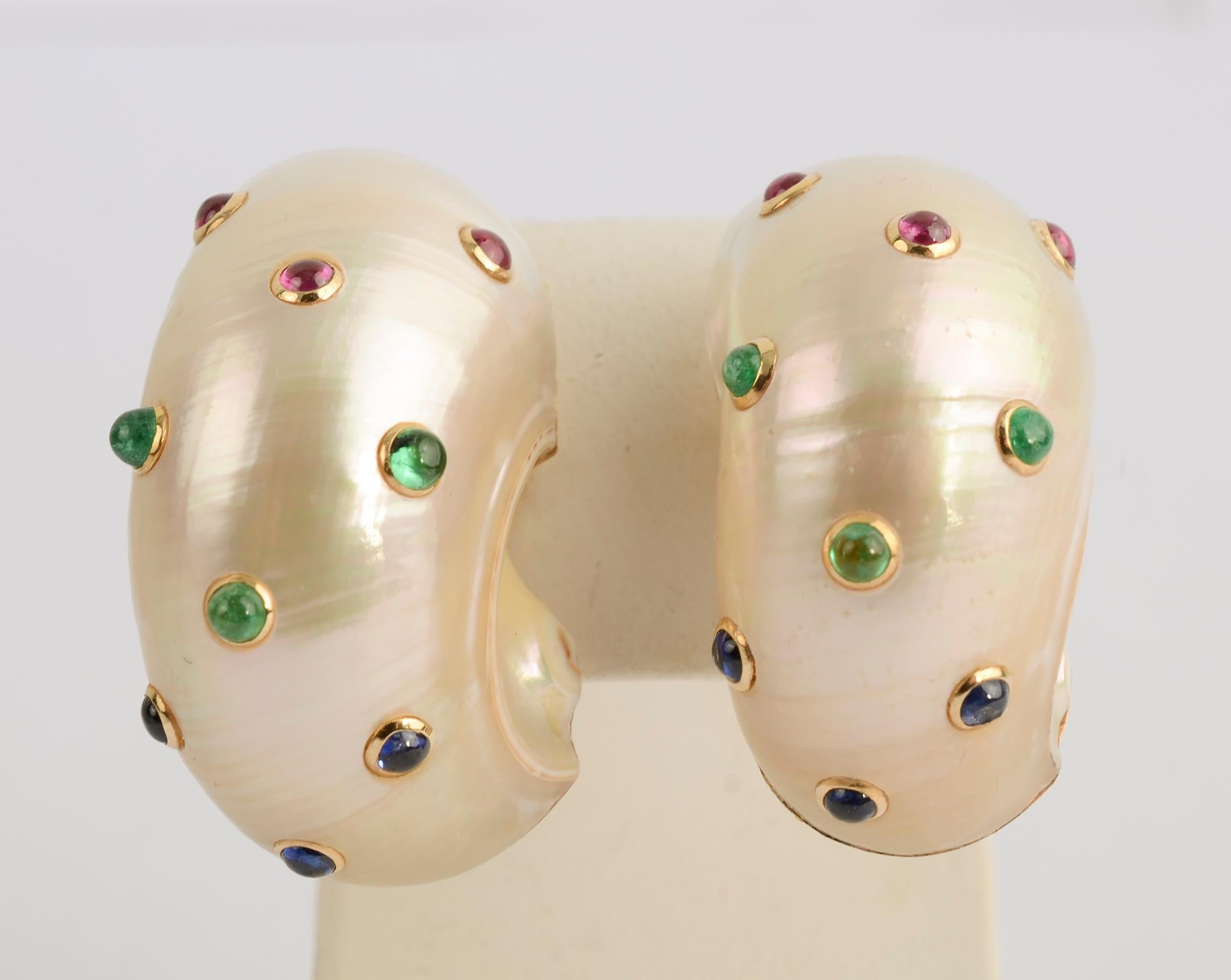 Large and voluptuous shell earrings by Trianon that are studded with cabochon rubies; sapphires and emeralds. The earrings measure 5/8