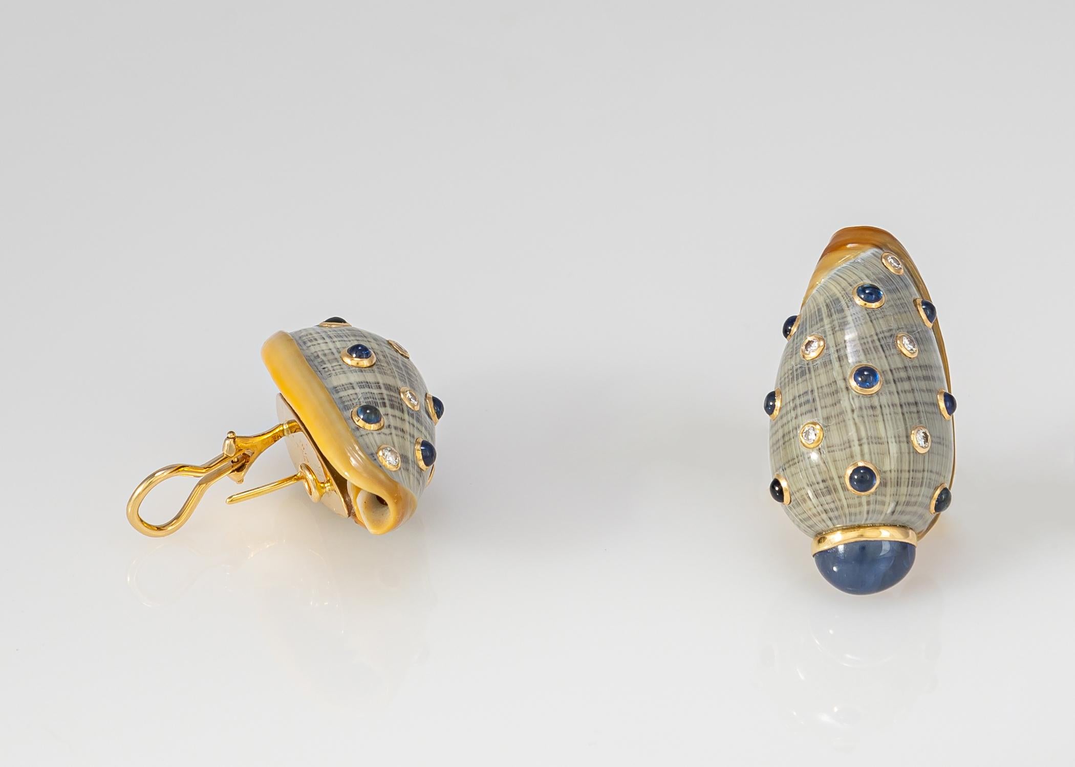 Trianon is famous for using natural shells to create unique earrings. This design has a matched pair of cabochon sapphires capping the lower end and is further accented with sapphires and diamonds. The color of the shells creates an opportunity to