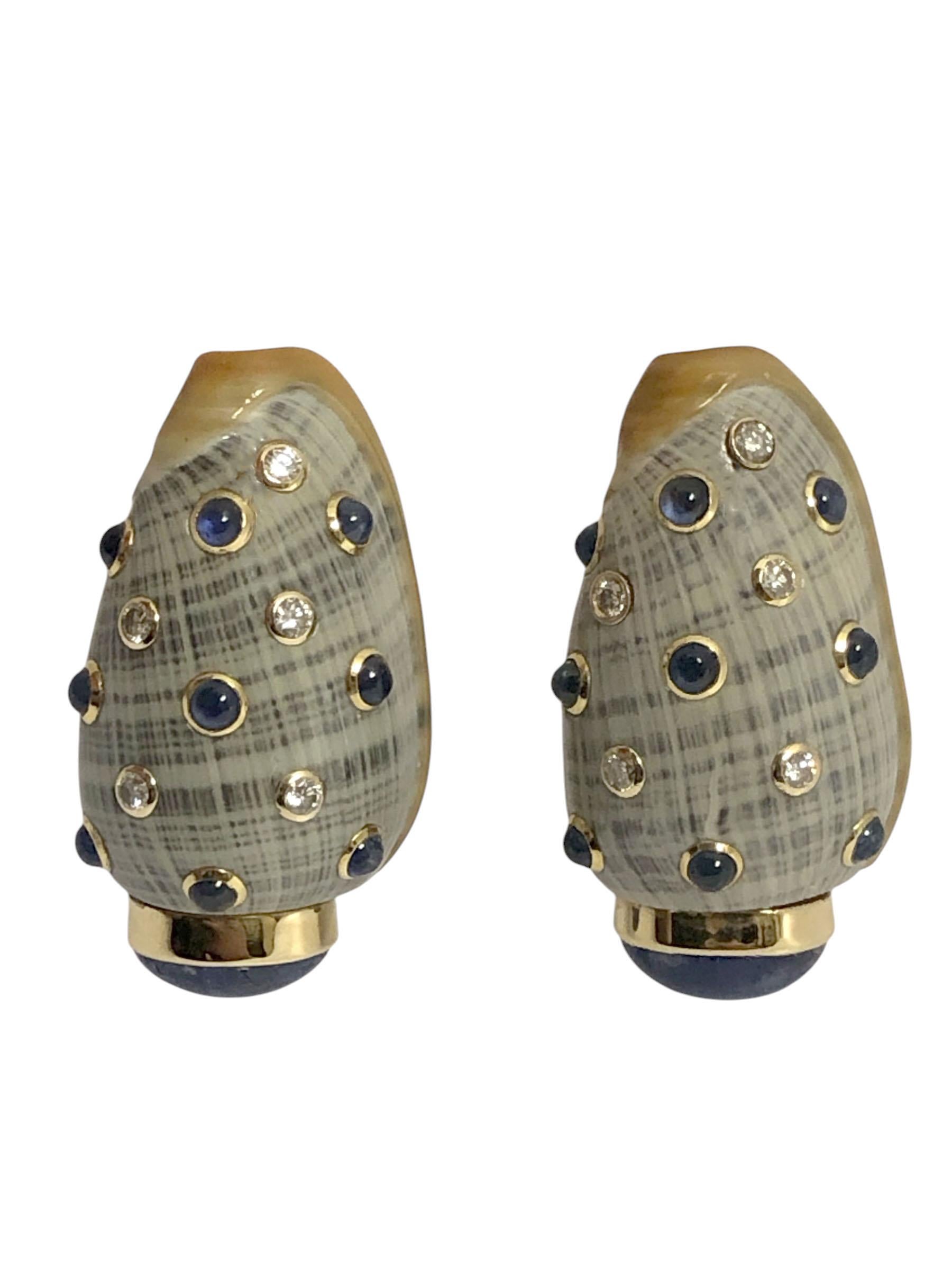 Circa 2000 Trianon light Gray and White Turbo Shell Earrings, measuring 1 3/8 inches in length, 1 inch wide and 1/2 inch thick, the bottom features a Bezel set Cabochon Sapphire of approximately 1.50 Carat and the shells are further Bezel set with