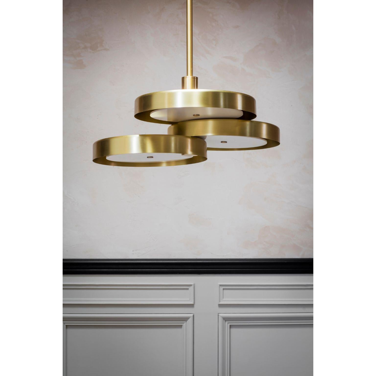 Triarc pendant light white by Bert Frank
Dimensions: 25 x 62 cm
Materials: Brass, acrylic

Available with opal or black diffusers.

Three intersecting brass discs hang from a single drop rod. Grouped together with two or more pendants – a trio of