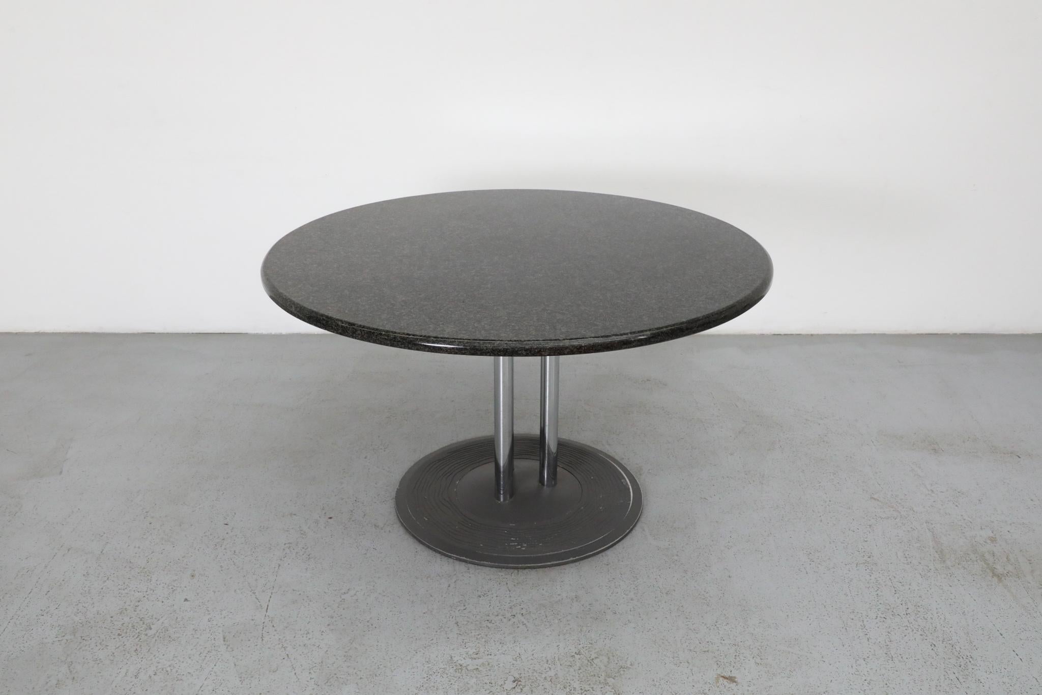 Round, 1980's, pedestal table with a dark granite top, three chrome posts and decorative round metal base. In a history filled with many exceptional designs, the 
