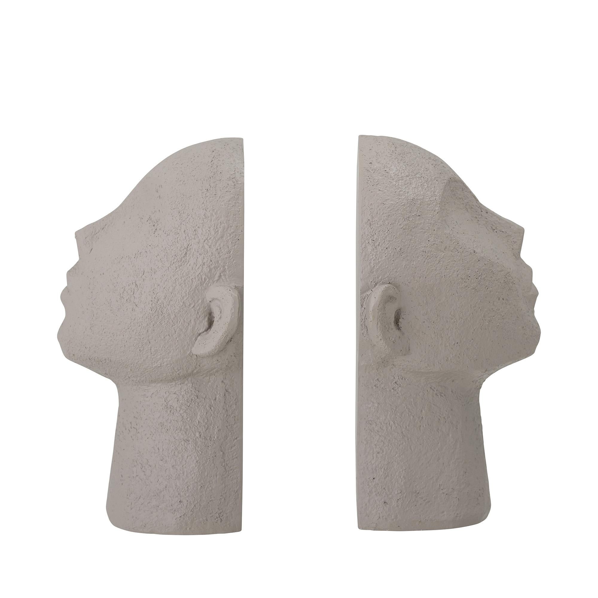 Set di fermalibri a due sculture in poliresina grigia, in cui ogni pezzo simula un volto tribale che guarda di lato.
Modellato e rifinito a mano. Si possono prevedere variazioni di texture.