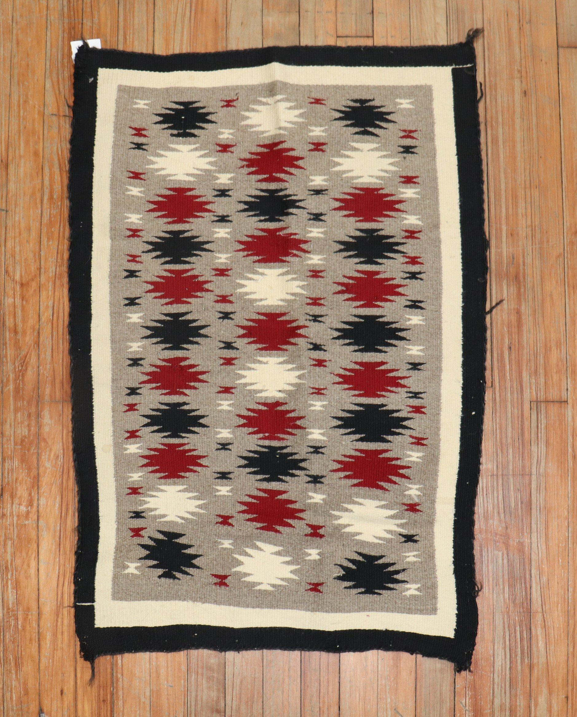 A highly decorative 20th-century American Navajo rug with an all-over geometric tribal pattern on a grey field.

Measures: 2'1'' x 3'1''.
 