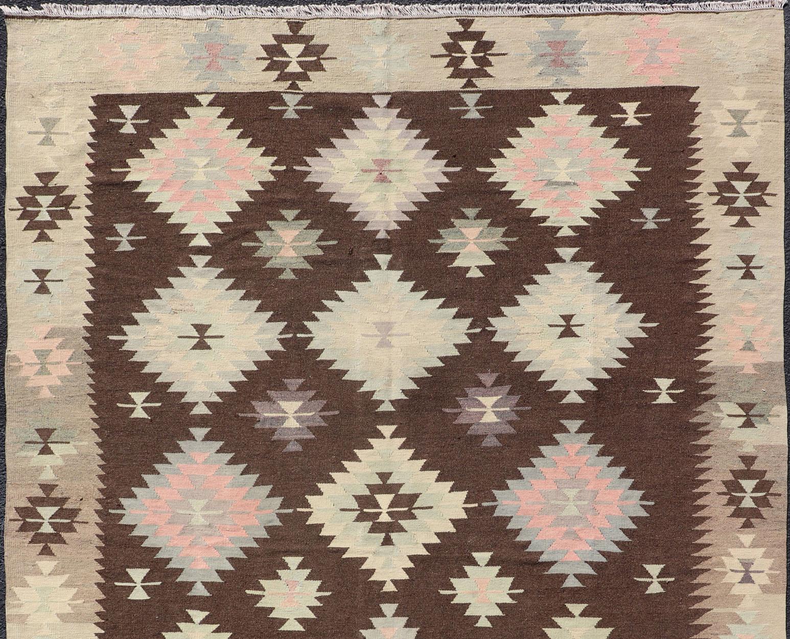 Turkish Kilim vintage in dark brown background and cream with graphic tribal design, Keivan Woven Arts rug/TU-NED-1009, country of origin / type: Turkey / Kilim, circa 1950.

Measures: 6'5 x 9'4

This unique Turkish Kilim features a graphic