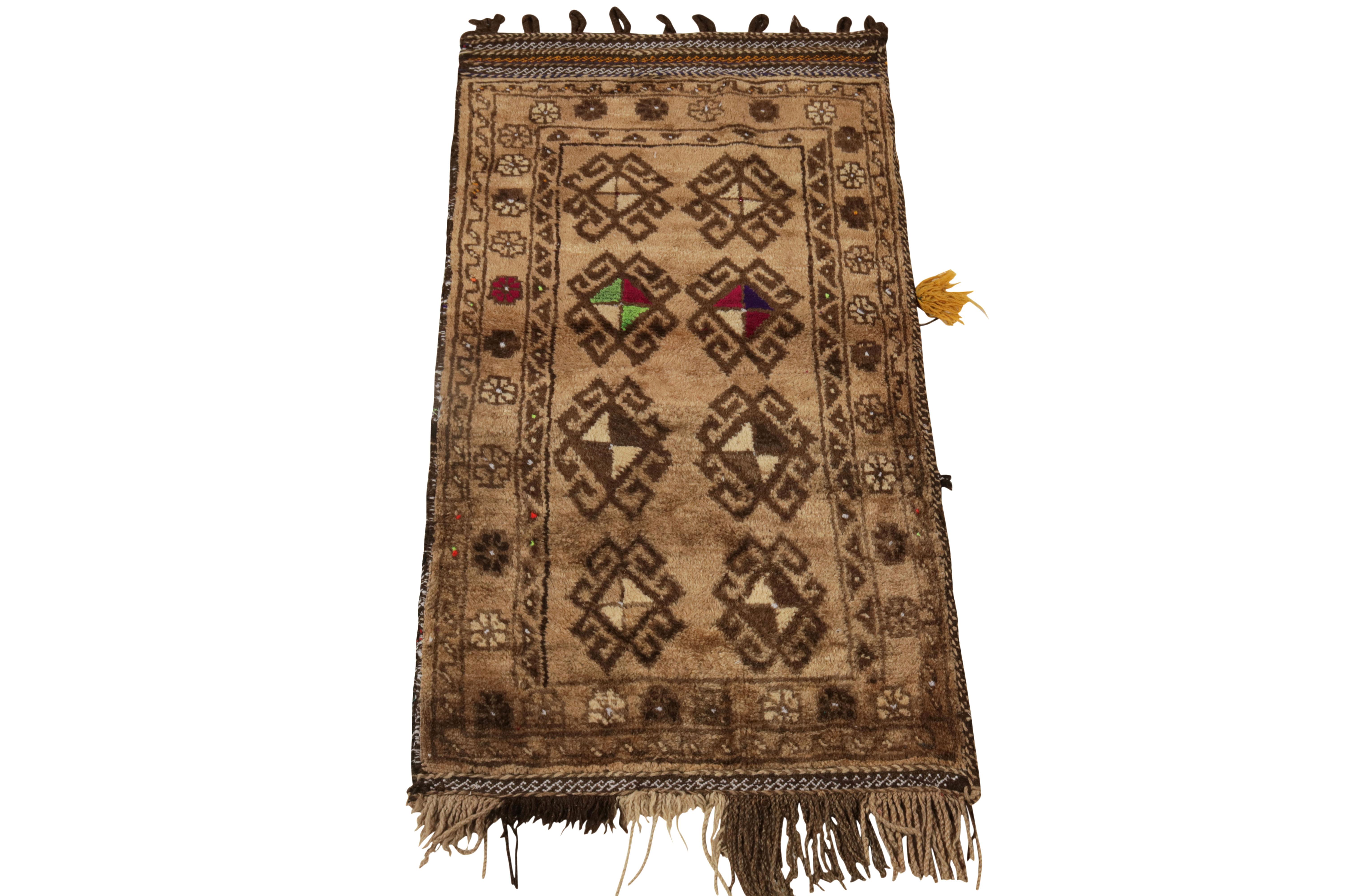 Rindiendo homenaje a la sensibilidad nómada de Baluchistán, una alfombra baluch antigua xX4 procedente de Persia hacia 1920-1930. El estilo tribal muestra un montaje de medallones de gancho y motivos tradicionales en colores marrón claro y beige