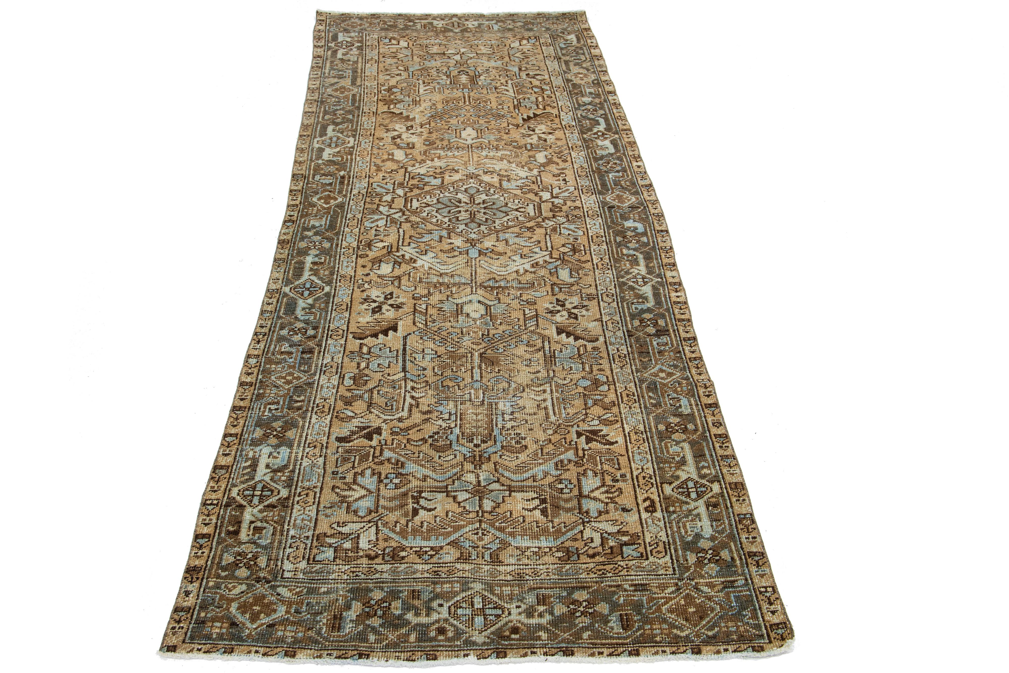Beautiful 20th-century Heriz hand-knotted wool runner with a brown color field. This Piece has blue accents in a gorgeous tribal design.

This rug measures 3'9