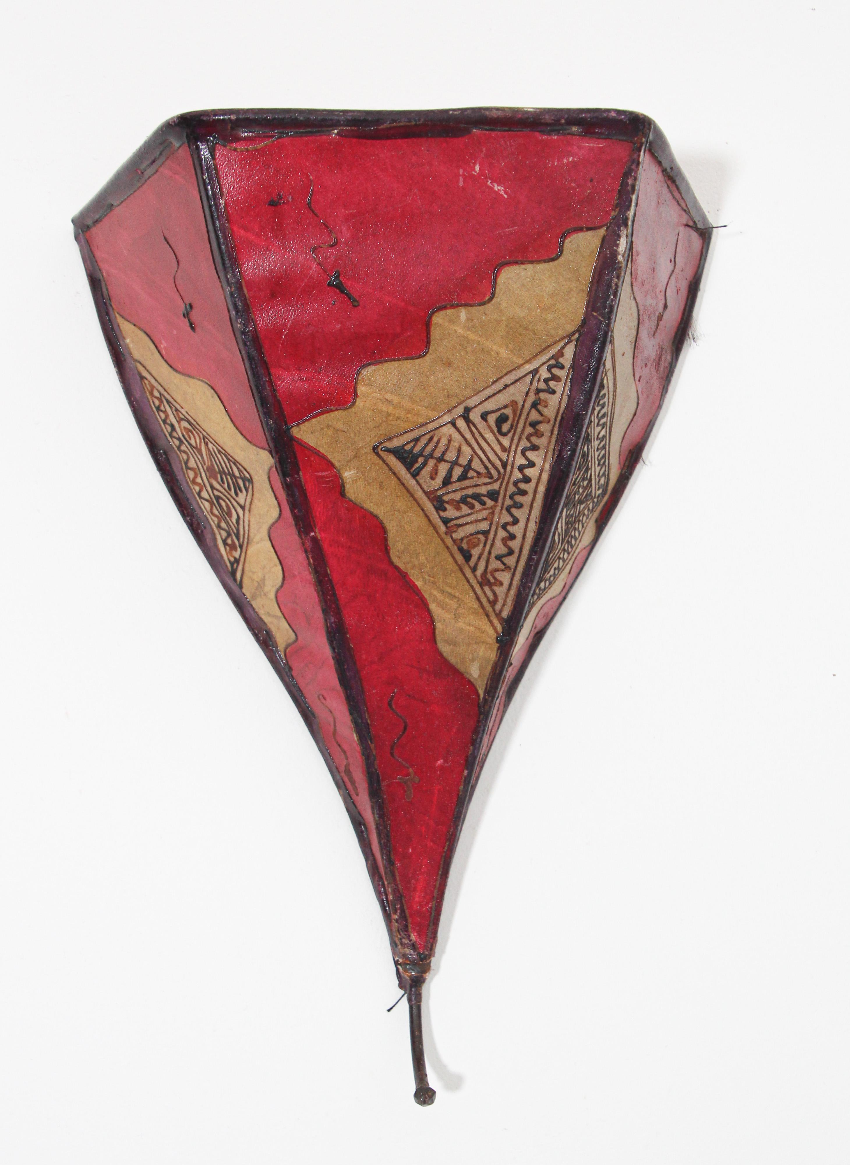 Afrikanische Stammeskunst Pergament Wandleuchte mit einer großen Dreiecksform aus Leder auf Eisen genäht und handbemalt Oberfläche.
Diese marokkanischen Kunstwerke können als Lampenschirm für die Wand verwendet werden.
Der mit Pergament überzogene