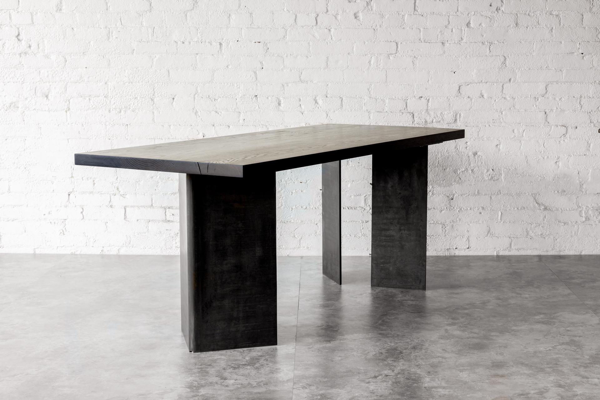 La table tribale utilise de l'acier laminé à chaud à grande échelle. Le concept, même s'il n'est pas littéral, est que l'avant de la table représente la proue d'un navire et les pieds arrière le gouvernail.  Ces pieds en acier laminé à chaud de 3/8