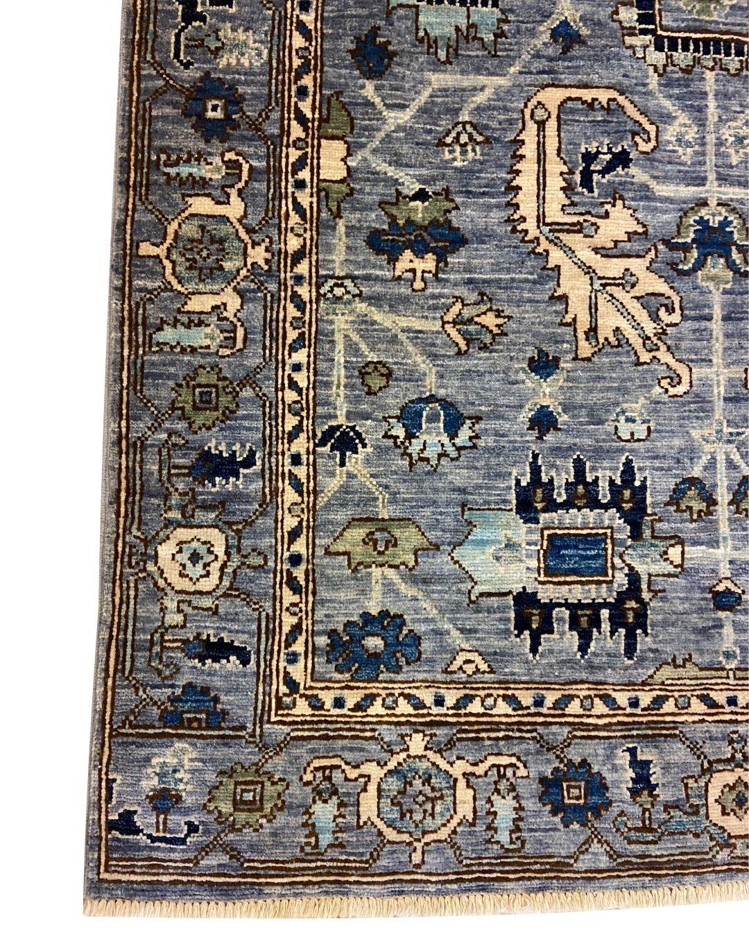 This tribal blue, cream, green & tan wool Persian rug, 3' x 5', showcases an intricate geometric design woven with meticulous craftsmanship, blending traditional Persian artistry with a modern, muted color palette. The delicate vine work meanders
