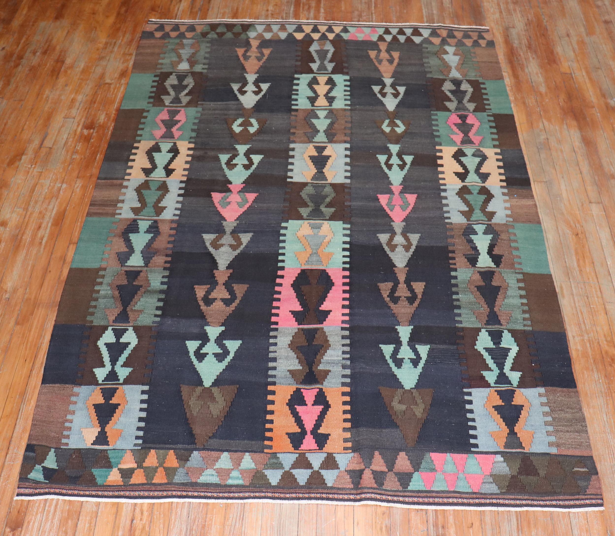 Tribal hand knotted mid-20th century Turkish Kilim / The background is brown and charcoal, accents in gray, light green, apricot and brown

Measures: 6'4'' x 9'5''.

 