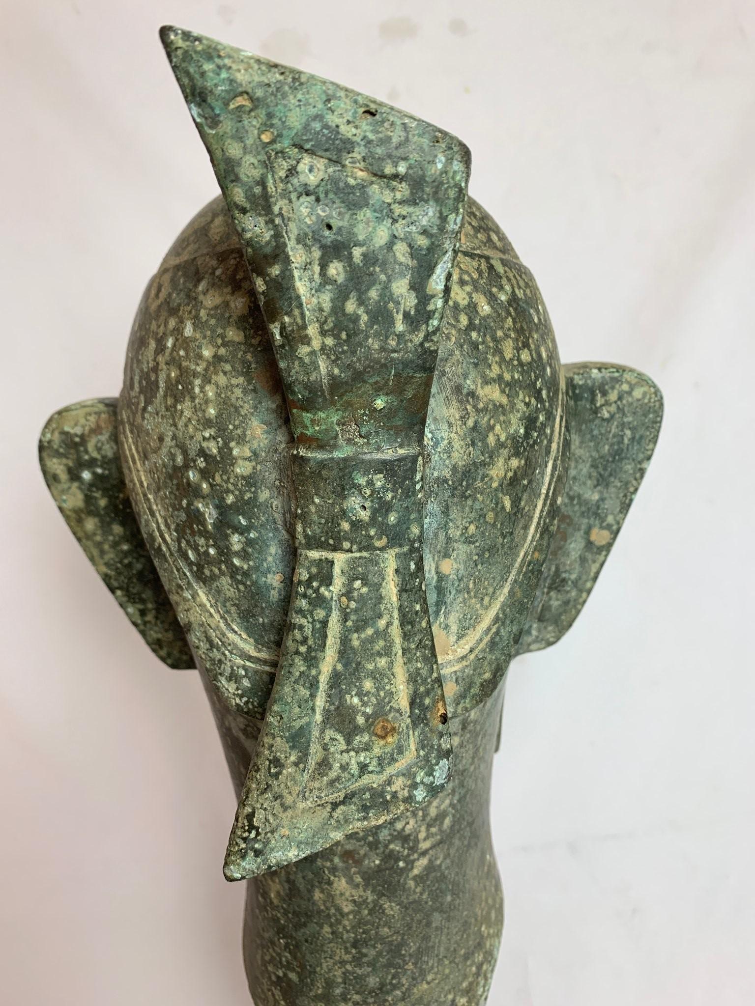 Tribal Chinese metal head sculpture on wooden pedestal, 1930s, possibly Sanxingdui replica.