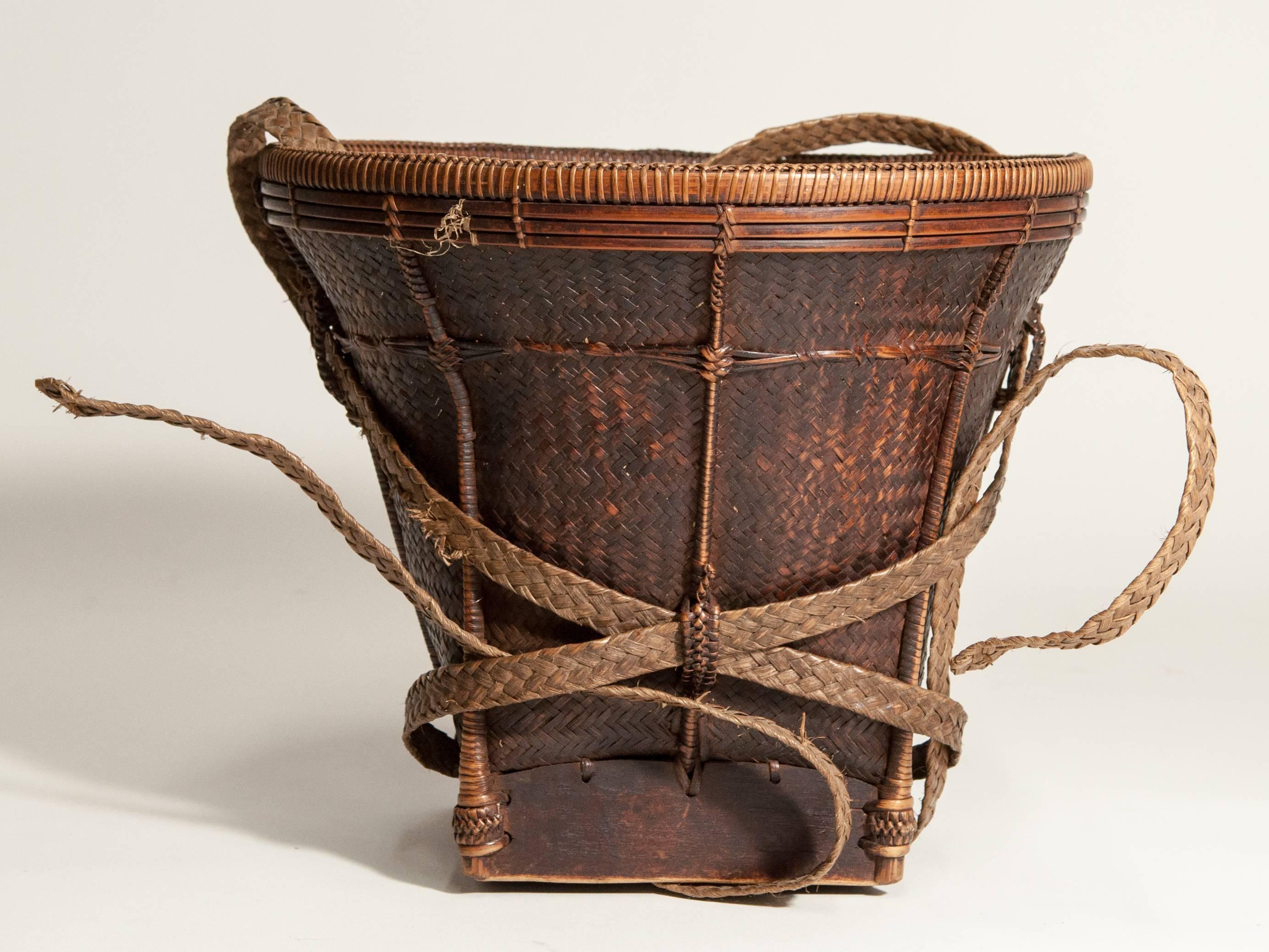 Small collecting basket from Ata Pue area of Laos, mid-20th century. Bamboo with a wooden base.
Finely woven collecting basket from the Ata Pue area of Laos dating to the mid-20th century. It is made of bamboo, using a variety of techniques and with