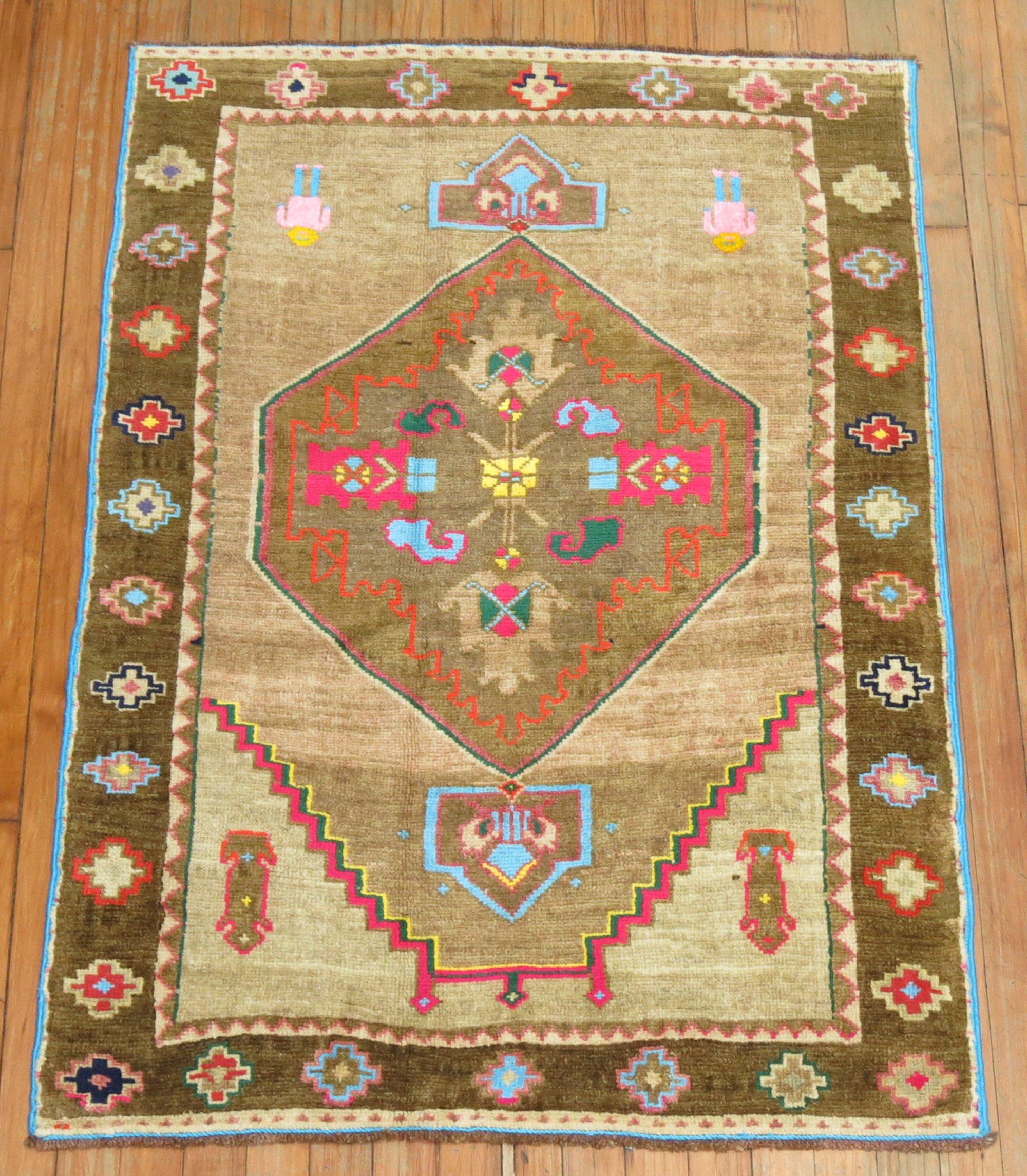 A mid-20th century Turkish Kars rug with cotton accents in bright intense colors. 2 humans dressed in pink and bright blue on 1 end. Blue side and cords added by the weaver too. A fun rug to own.

Measures: 2'10