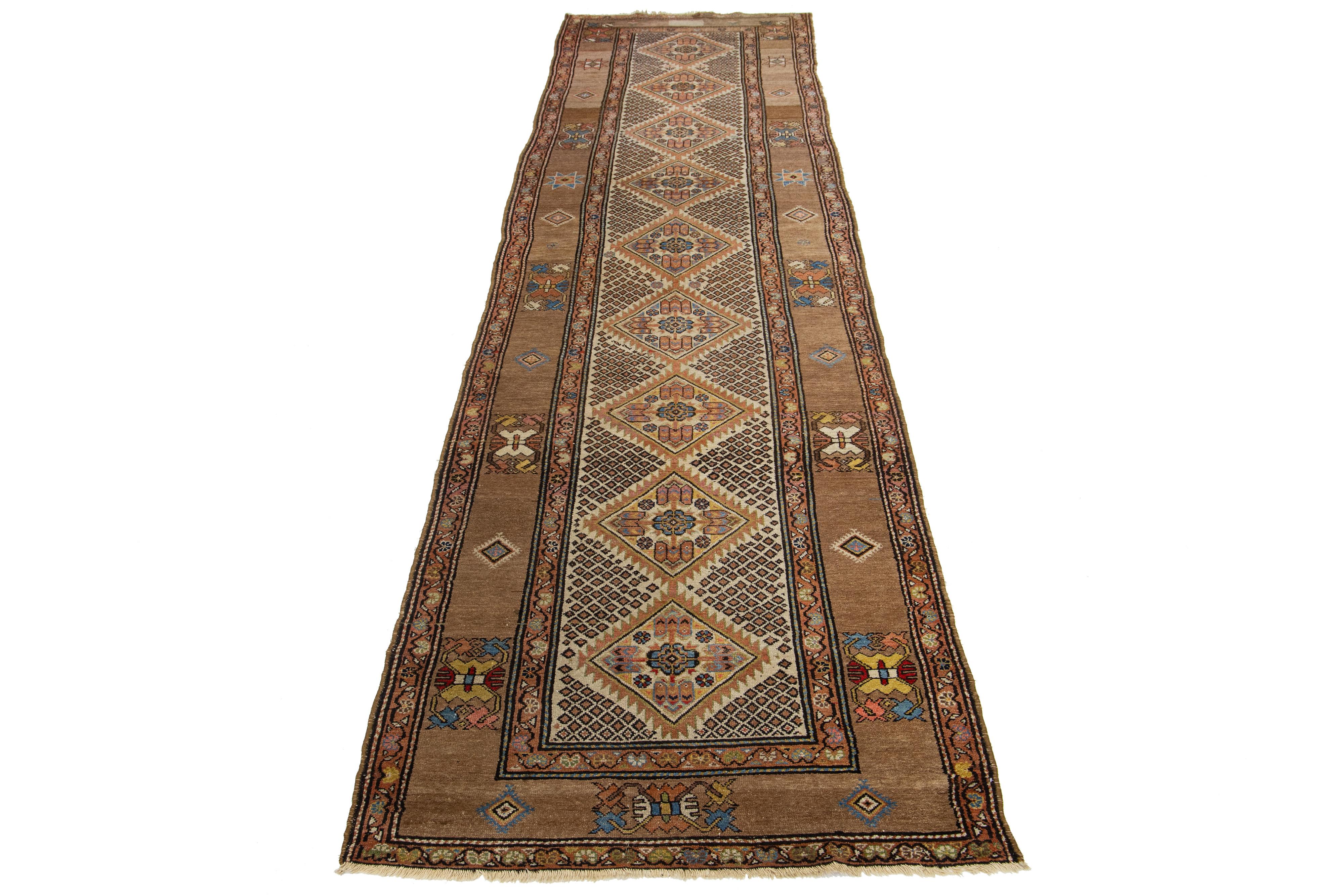 This beautiful antique Malayer hand-knotted wool runner features a beige color field. The Persian rug showcases a stunning all-over design with accents of blue, peach, and brown.

This rug measures 3'9